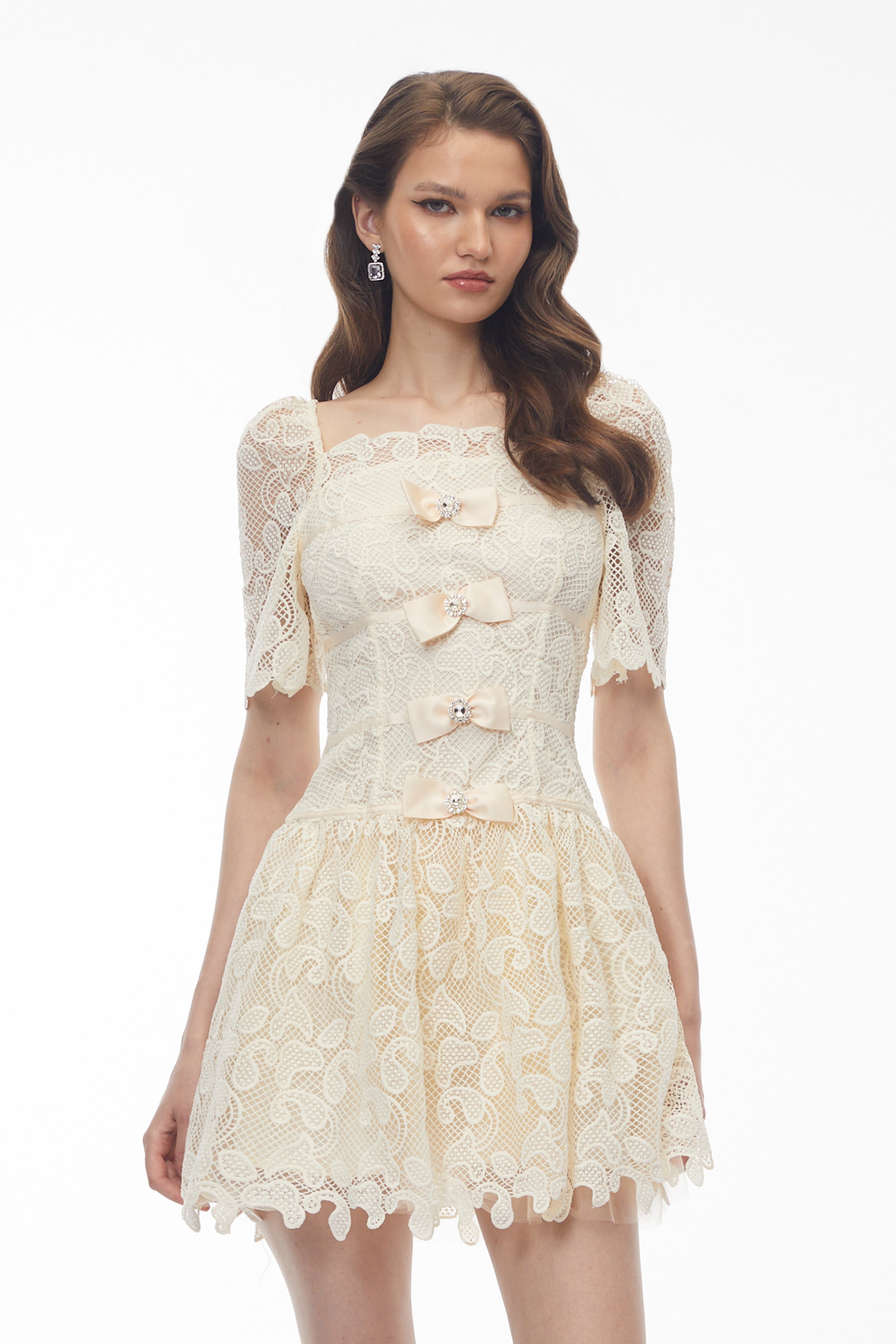 Cream lace mini dress with bow accents and crystal details