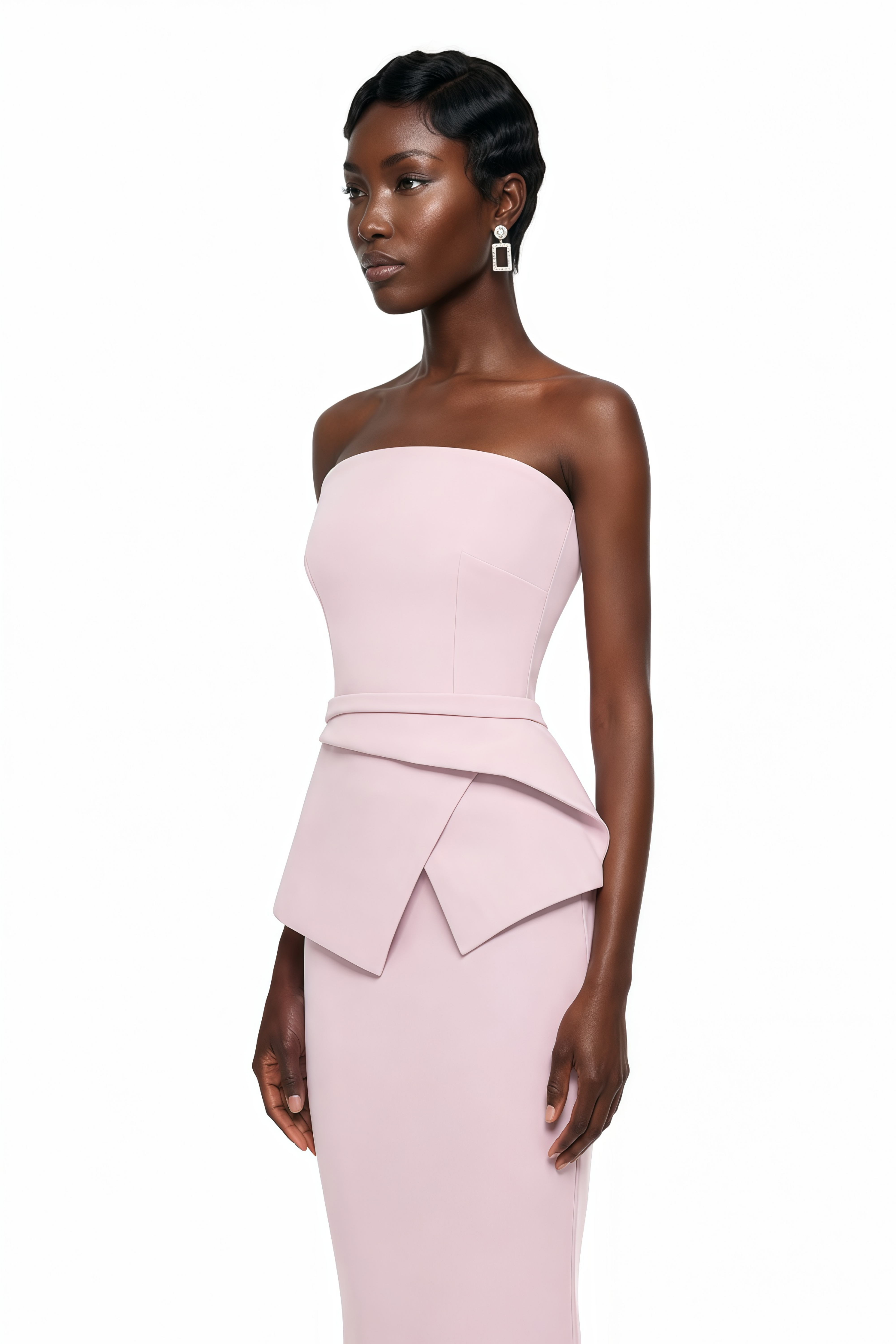 Light pink strapless maxi dress featuring a structured bodice and a geometric asymmetric peplum waist