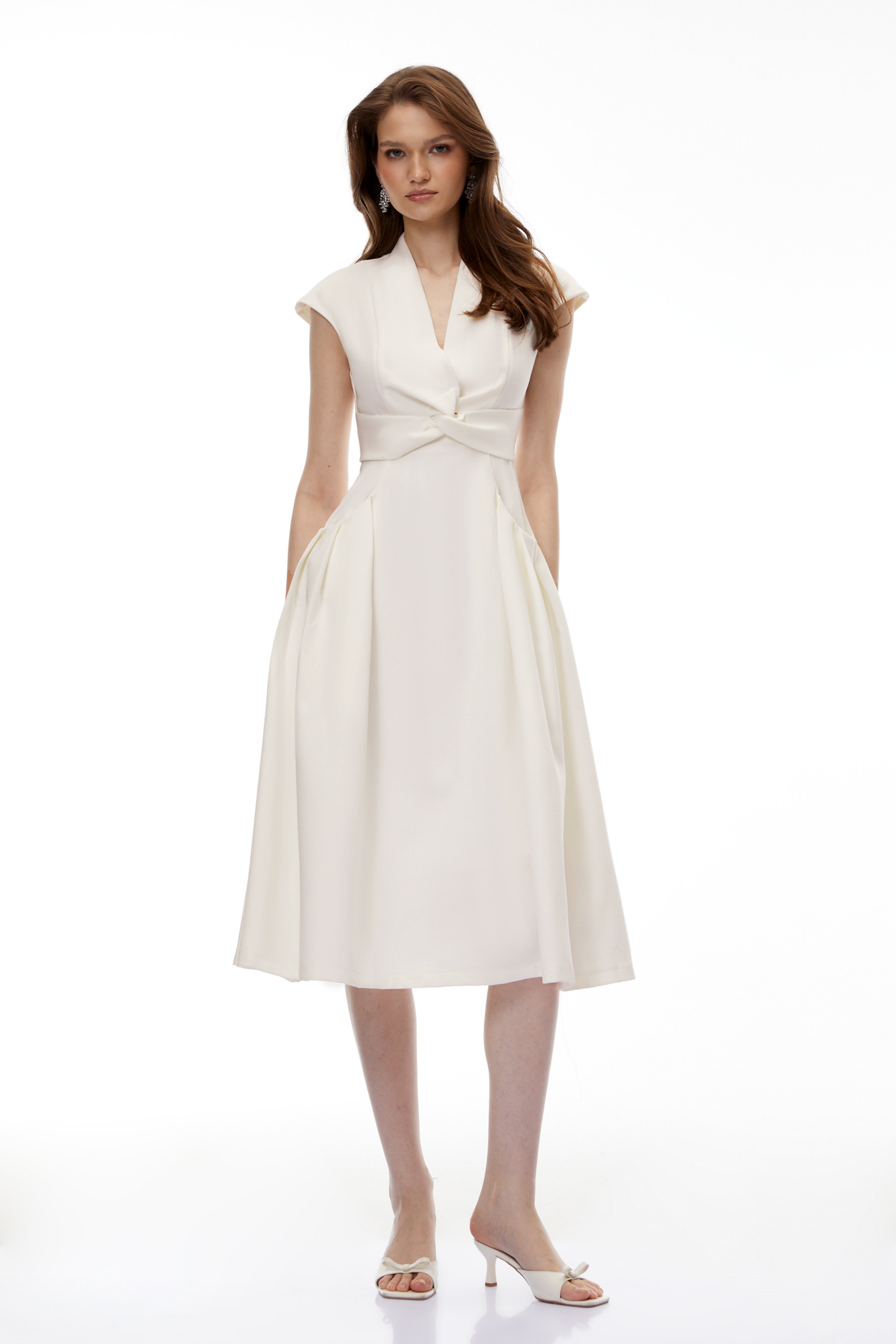 White midi dress with a surplice V-neckline, capped sleeves, and a structured A-line skirt
