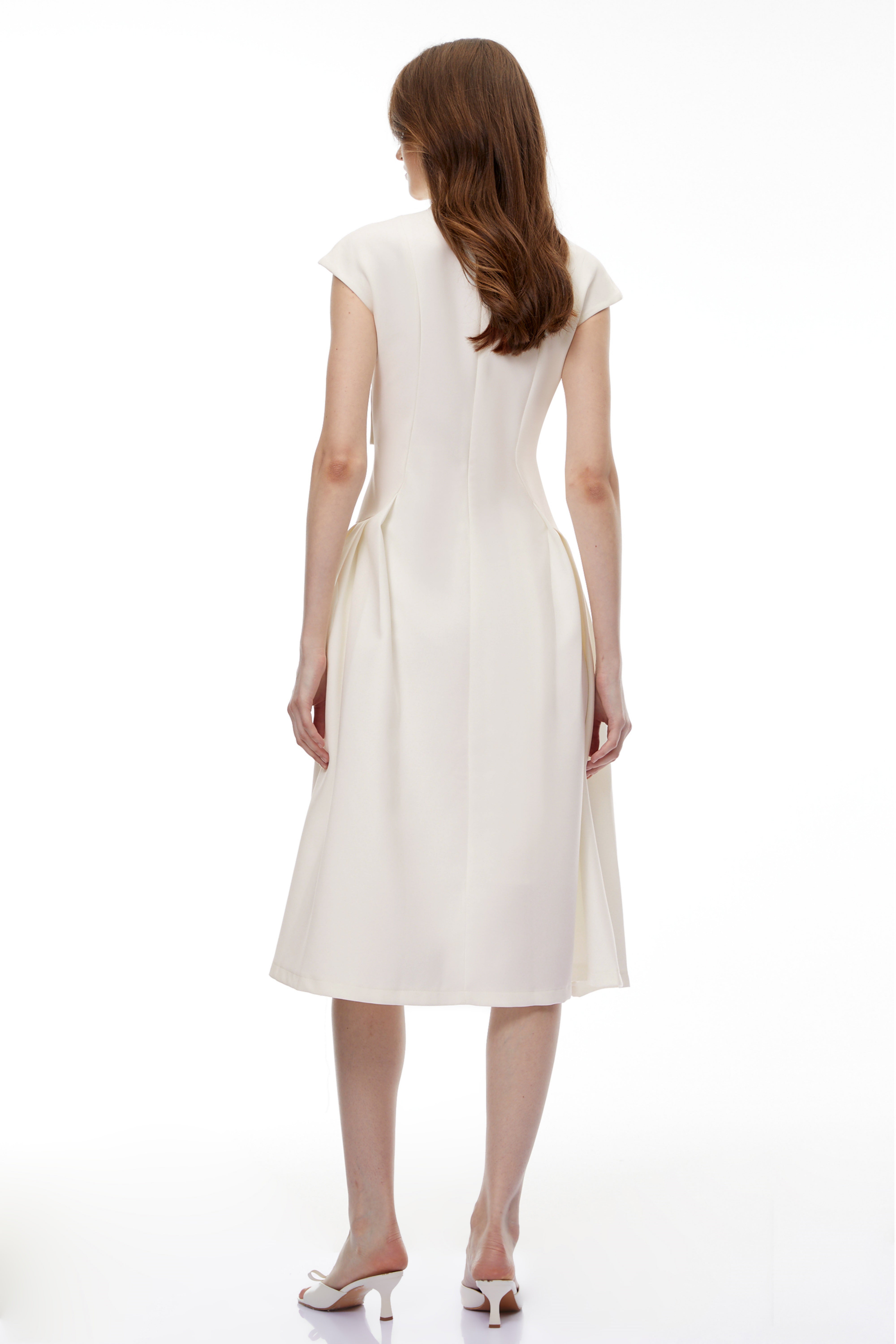 White midi dress with a surplice V-neckline, capped sleeves, and a structured A-line skirt
