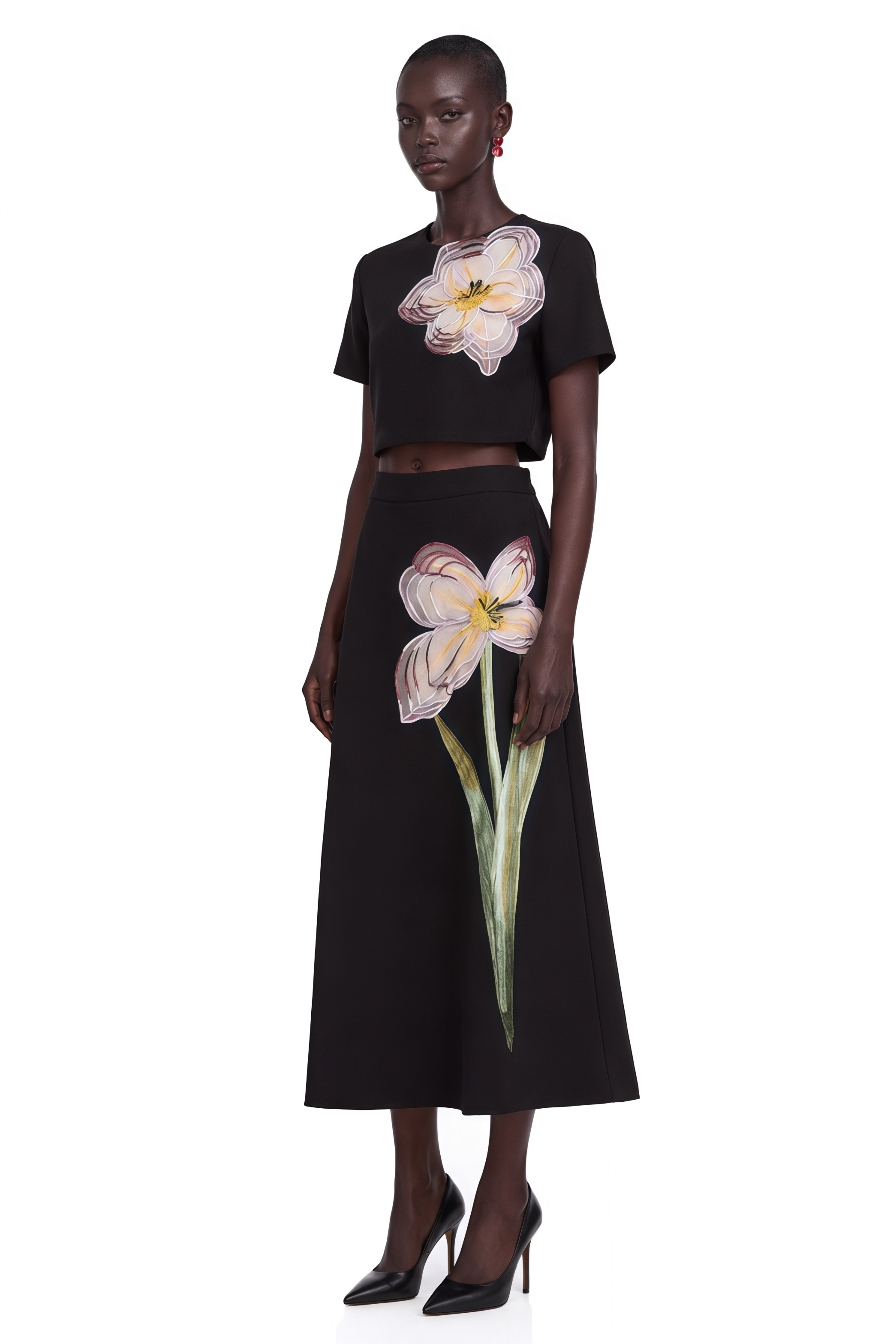 Black short-sleeve crop top and maxi skirt set with large floral embroidery.