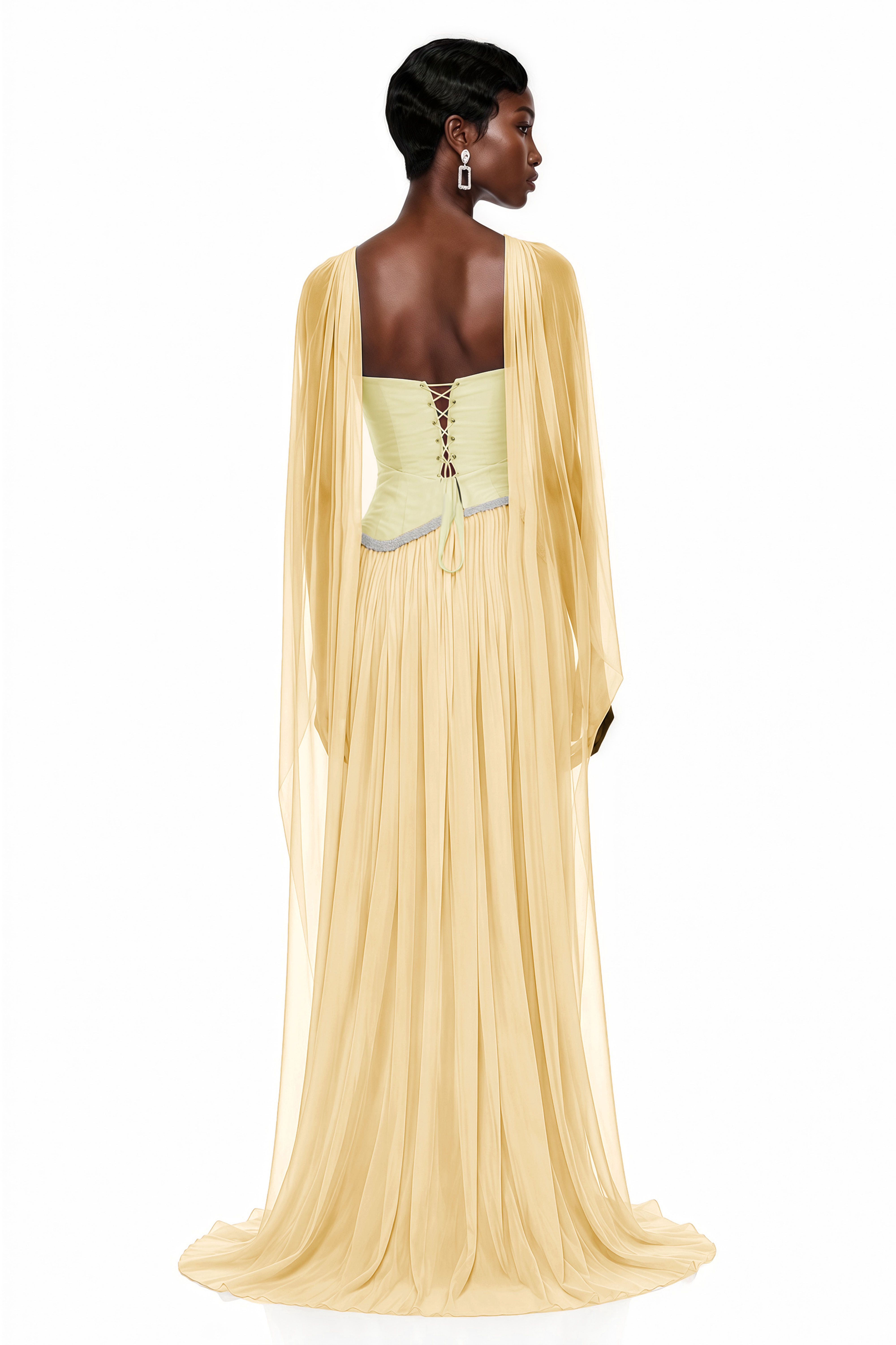 Pale yellow pleated gown with embellished trim and draped cape