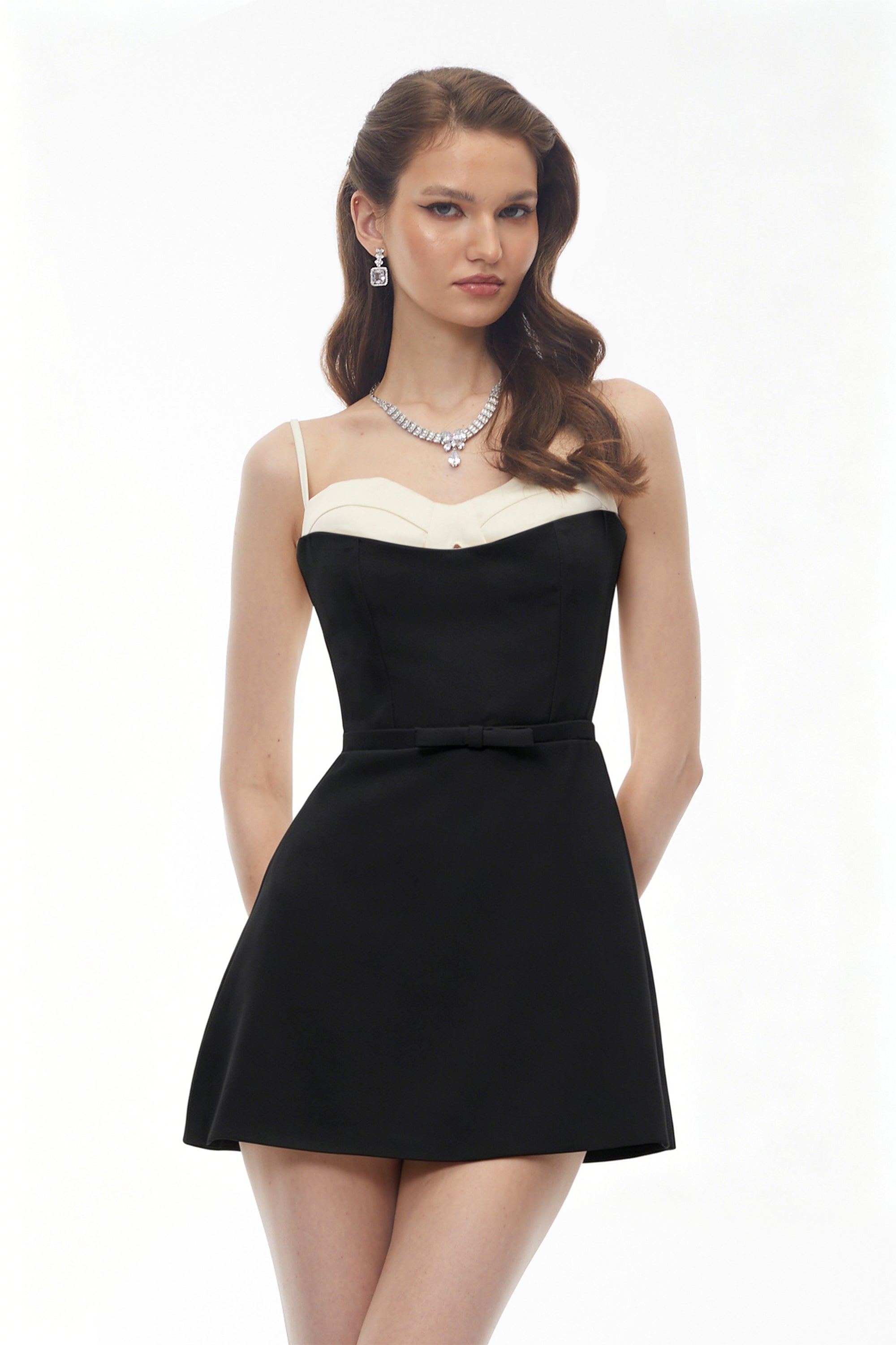 Black mini dress featuring a white contrast bustier and thin spaghetti straps