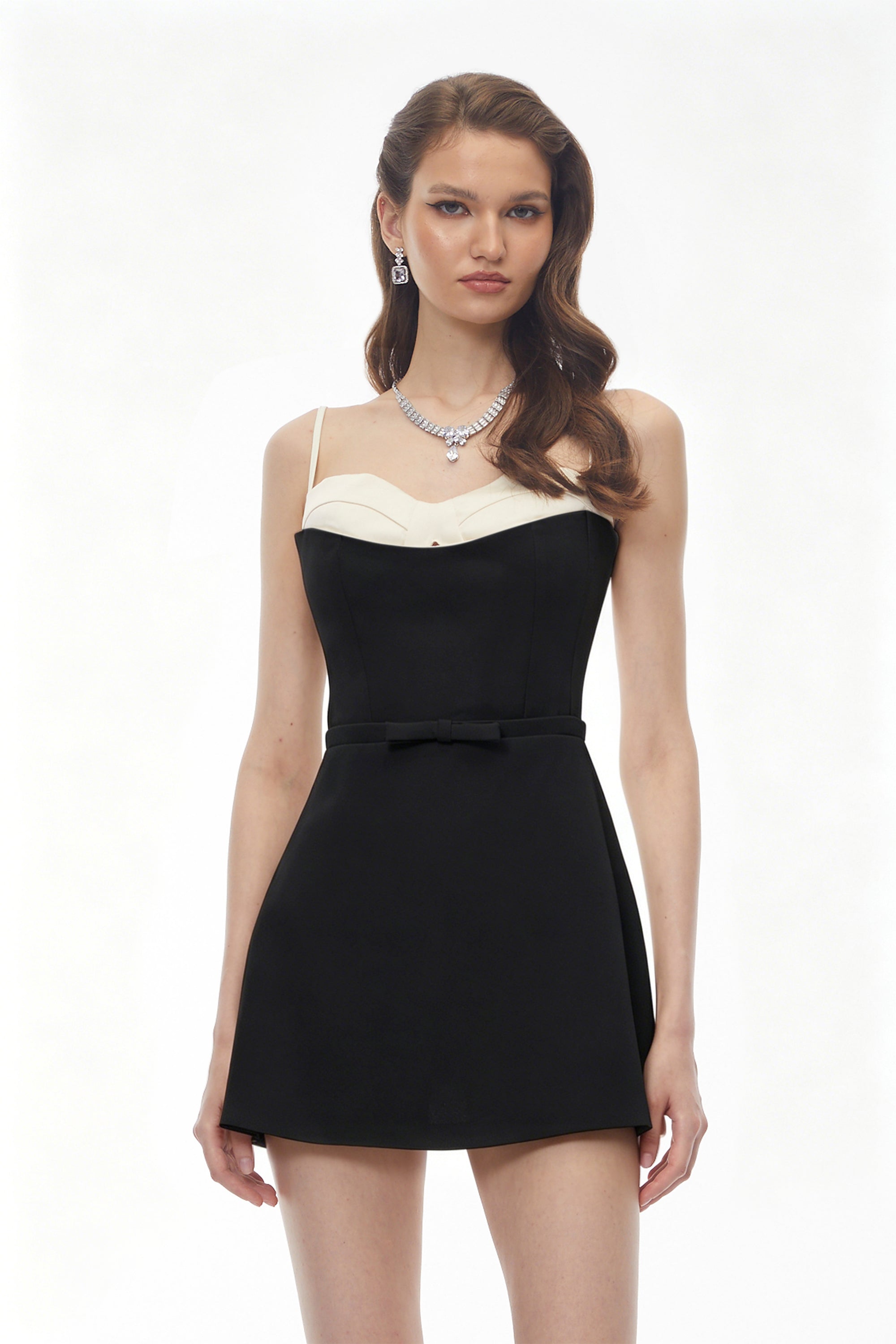 Black mini dress featuring a white contrast bustier and thin spaghetti straps