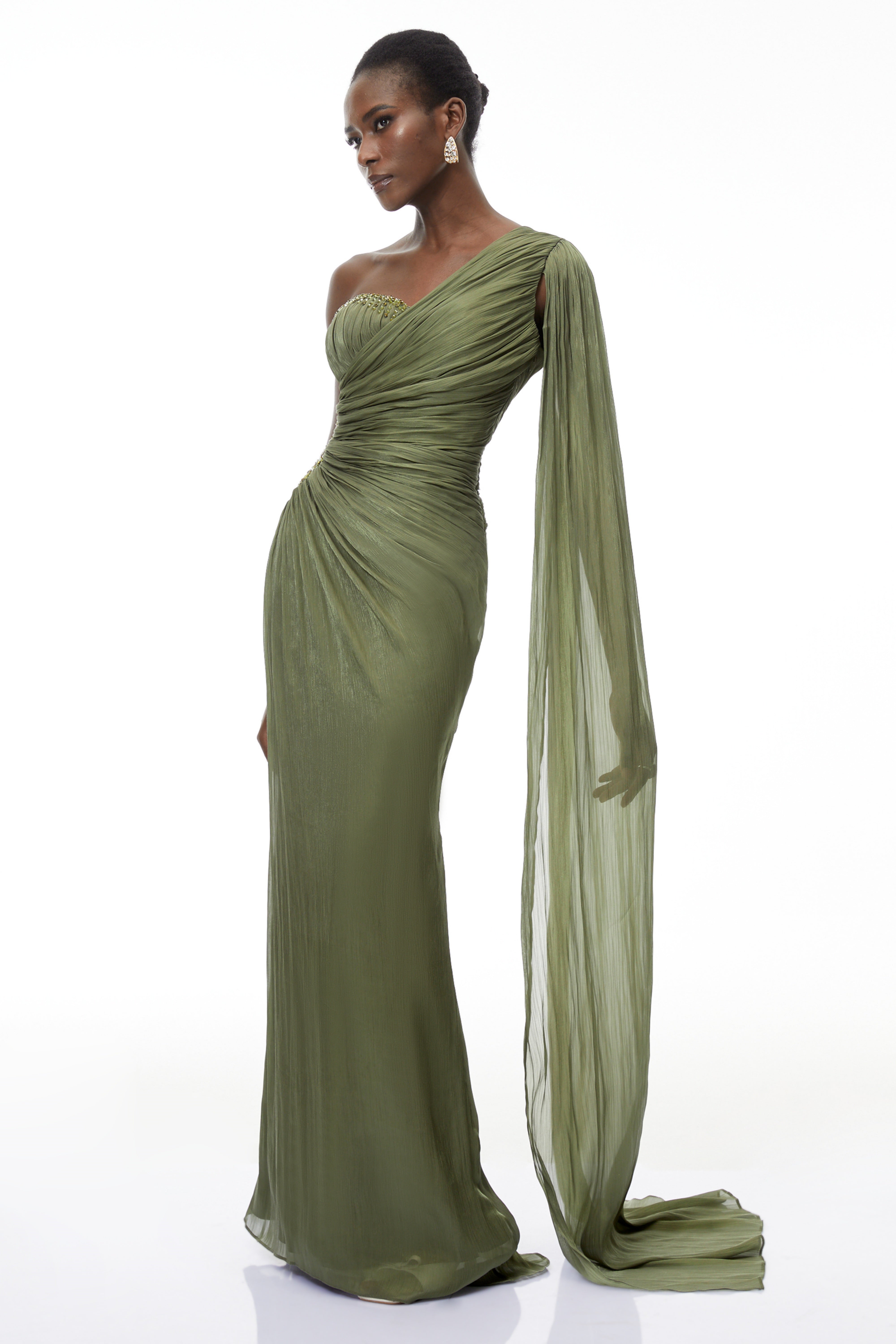 Olive green pleated one-shoulder gown with beaded embellishments and a long draped shoulder cape