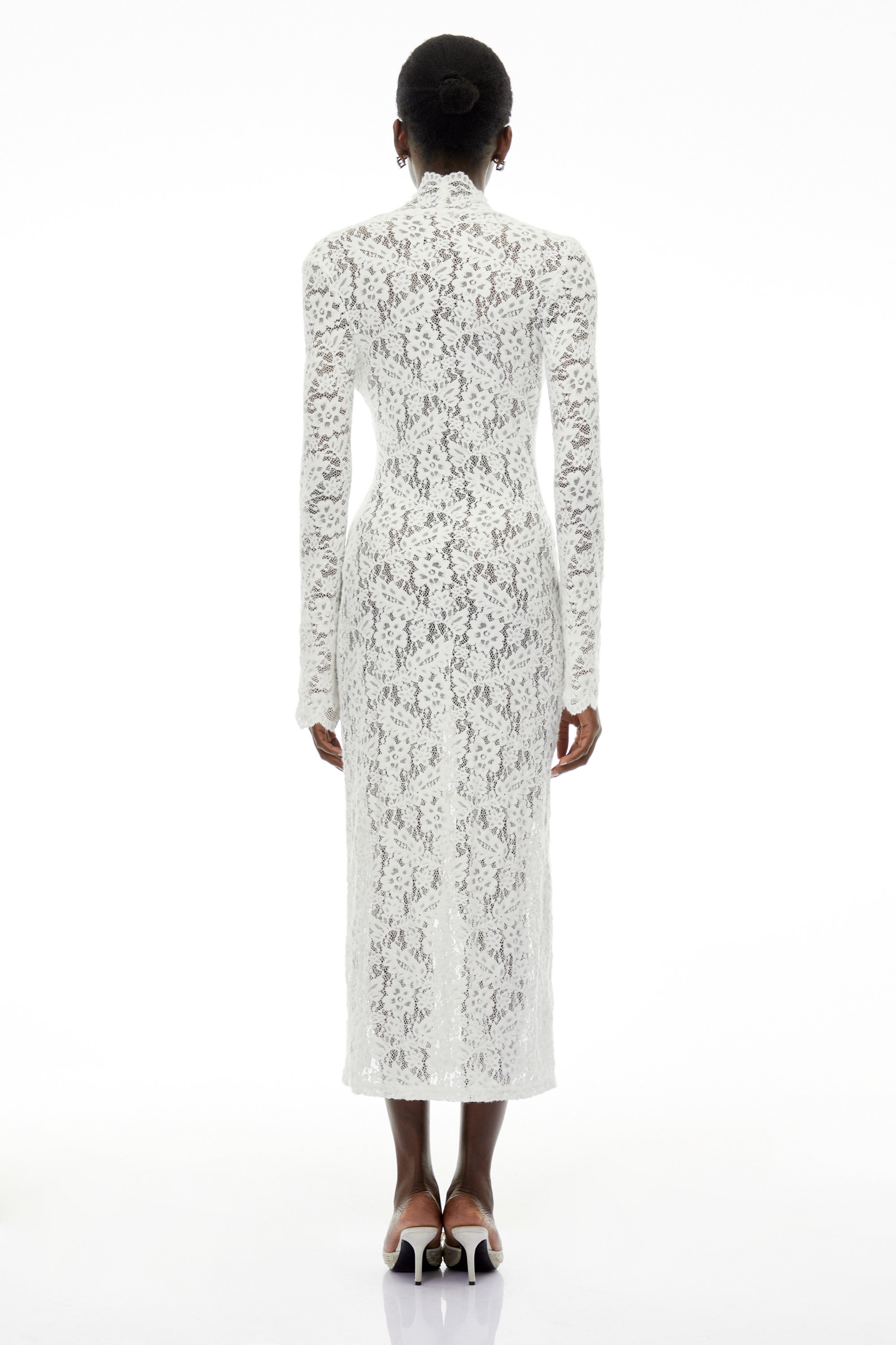 White lace maxi dress with a lace-up plunging neckline, long flared sleeves, and a high front slit