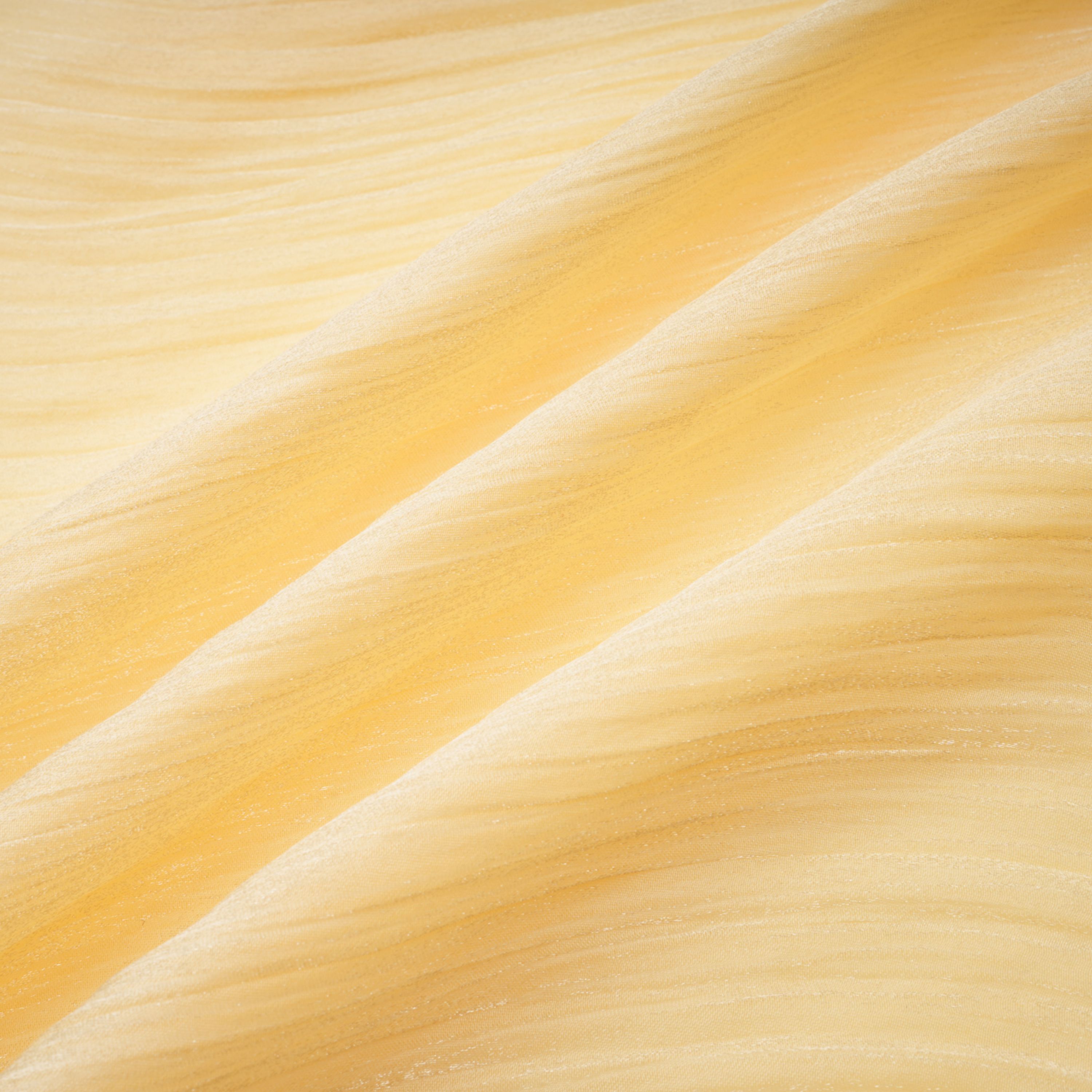 Pale yellow one-shoulder plissé maxi dress with a draped high slit and a trailing hem