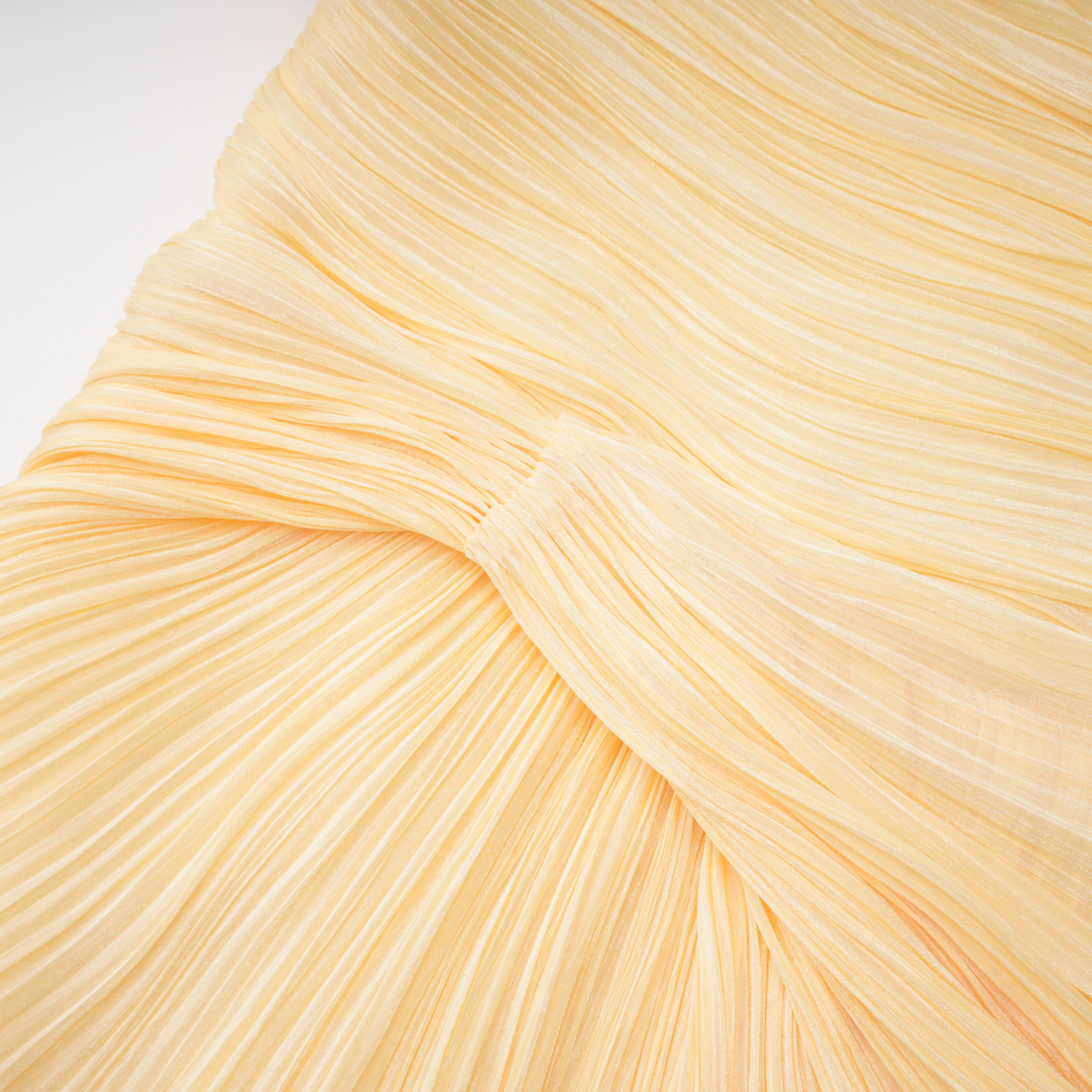 Pale yellow one-shoulder plissé maxi dress with a draped high slit and a trailing hem