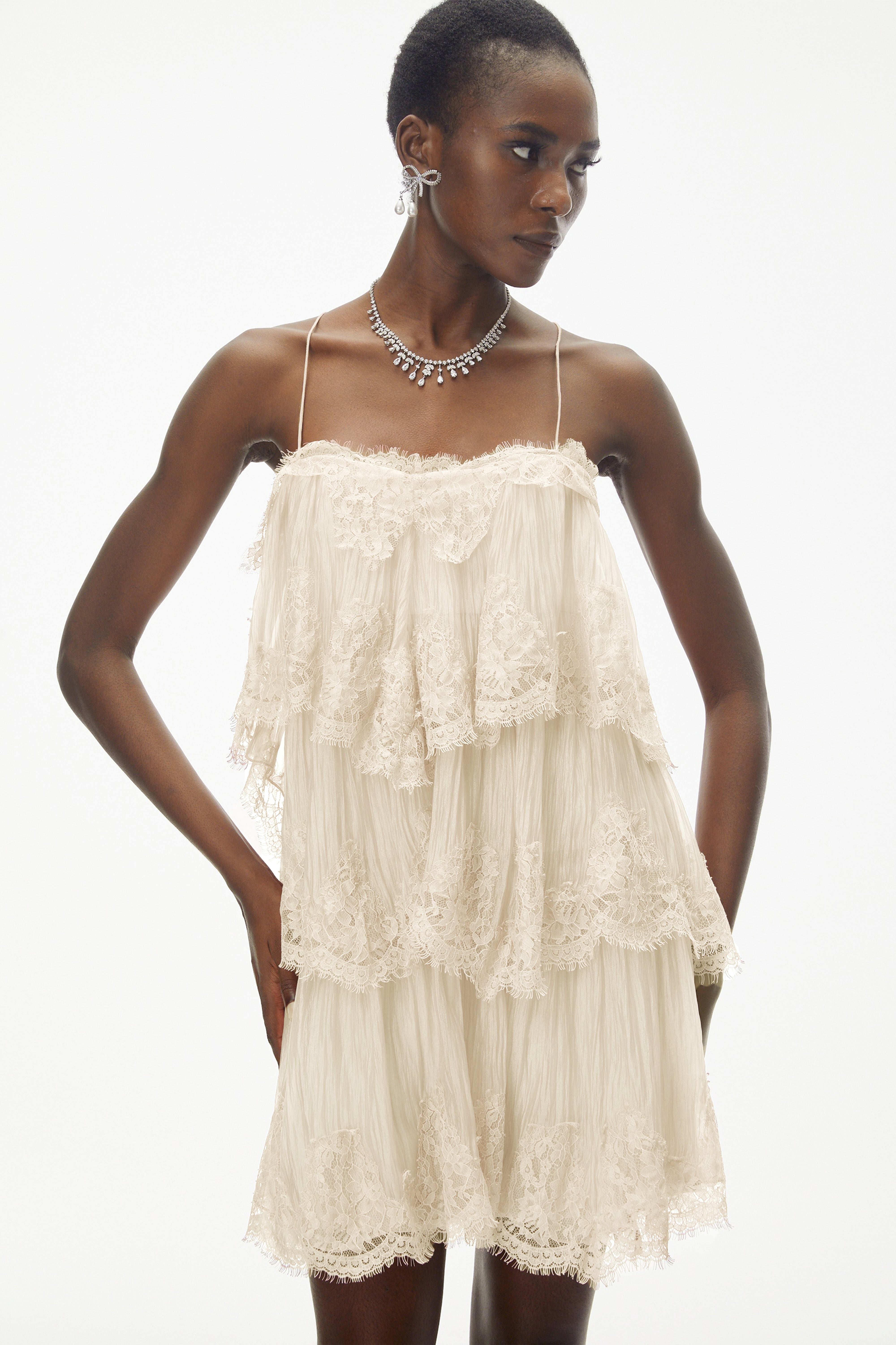 Champagne tiered mini dress featuring delicate lace trim and thin spaghetti straps