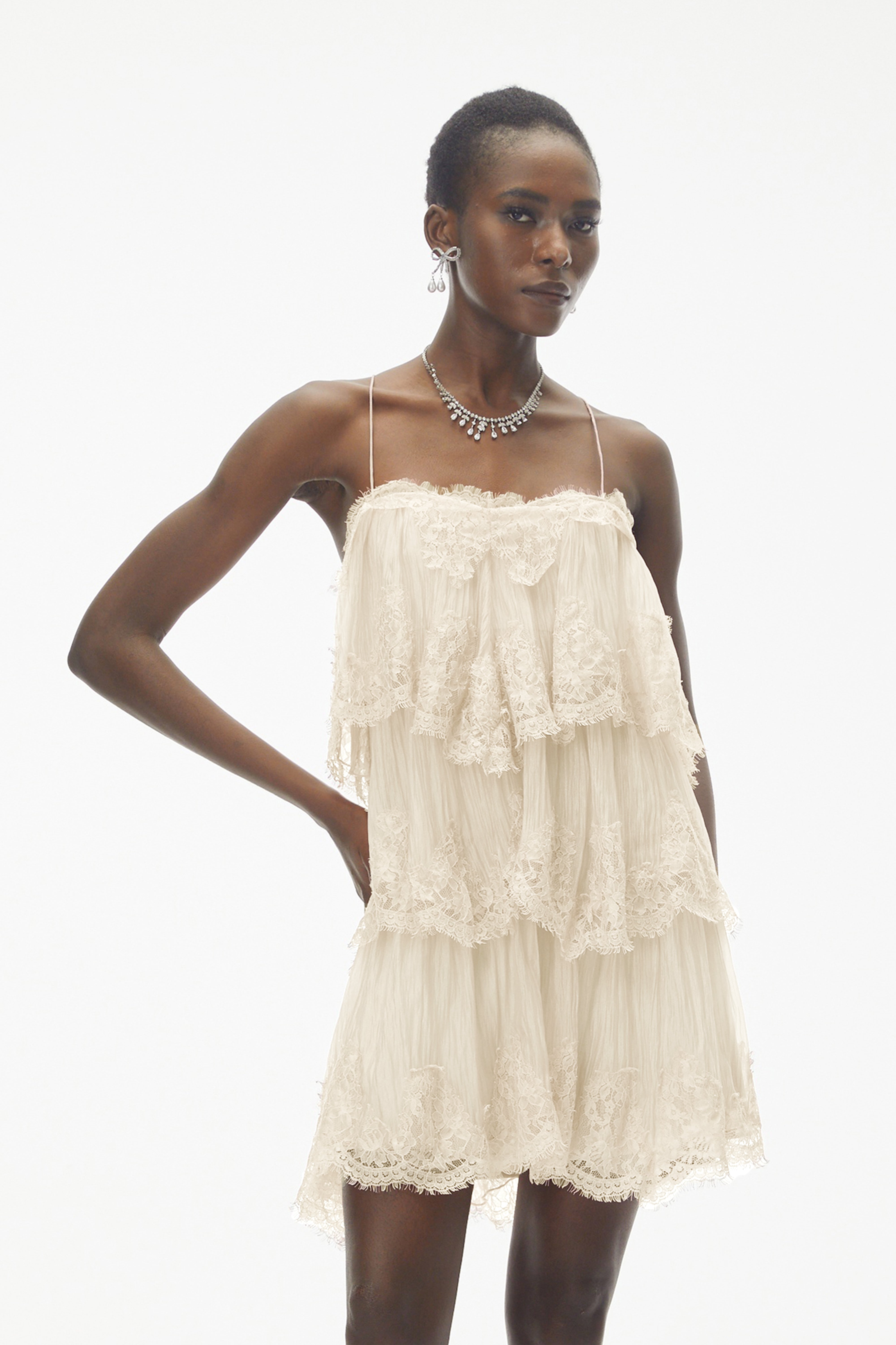 Champagne tiered mini dress featuring delicate lace trim and thin spaghetti straps