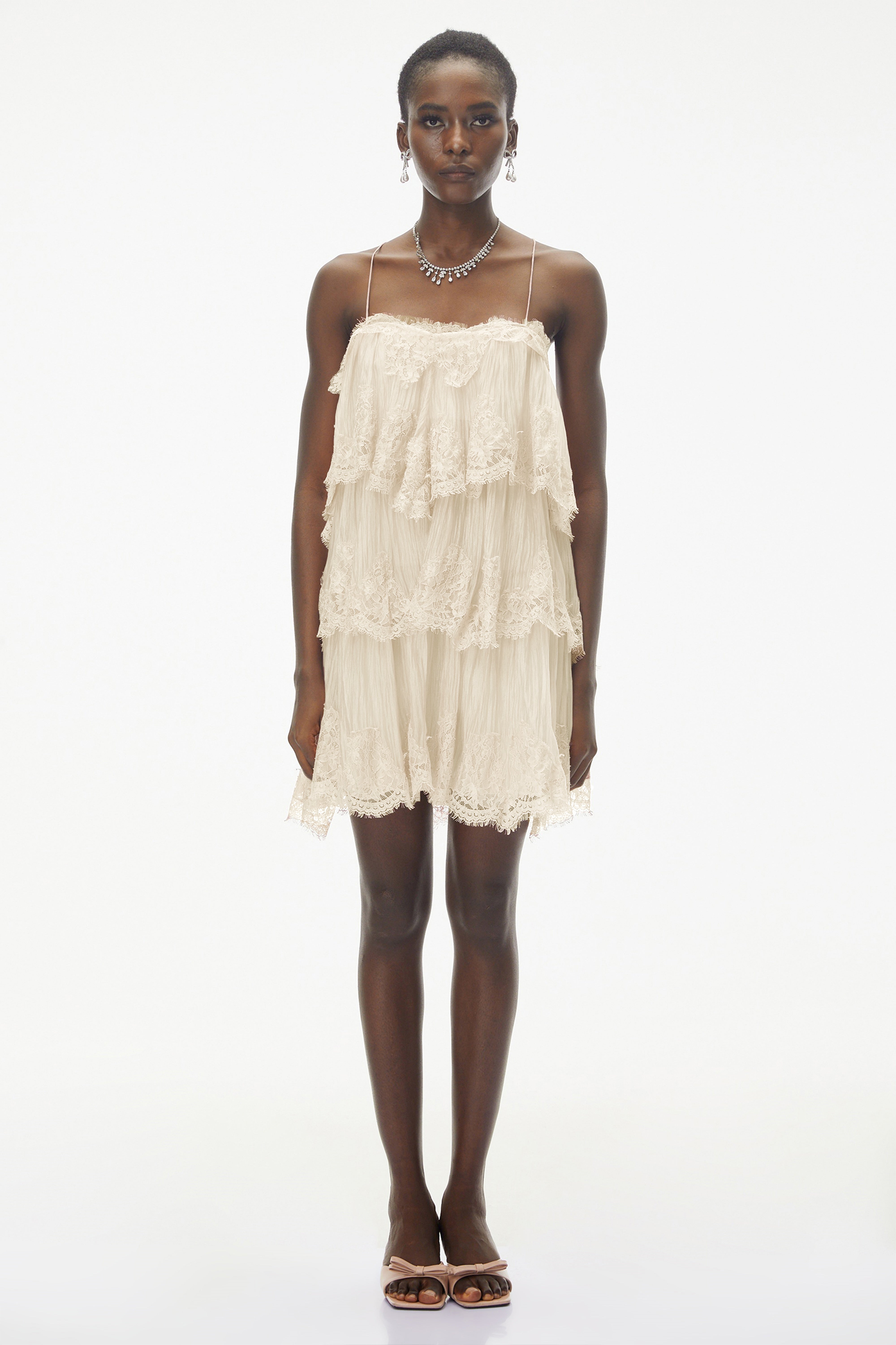 Champagne tiered mini dress featuring delicate lace trim and thin spaghetti straps