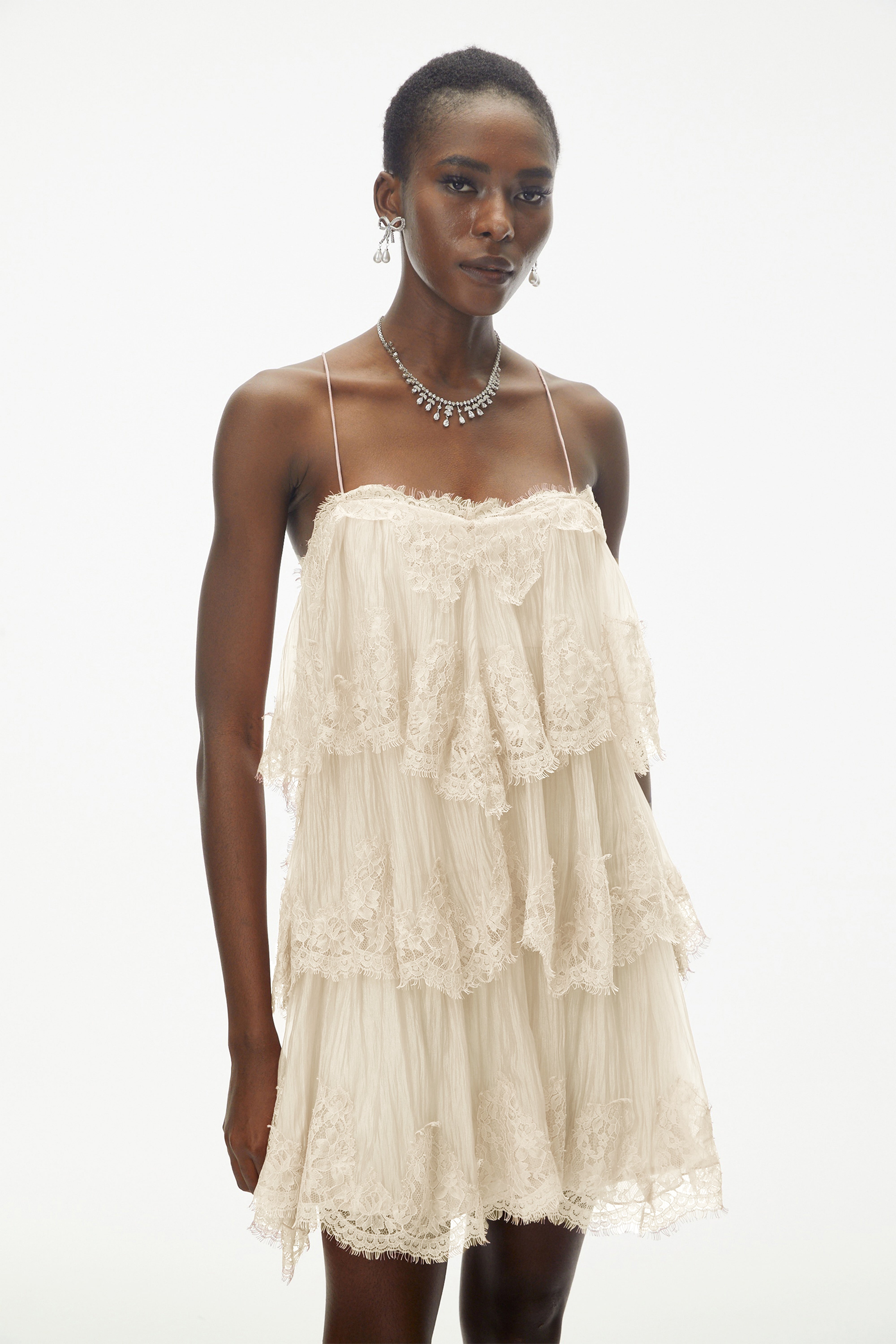 Champagne tiered mini dress featuring delicate lace trim and thin spaghetti straps