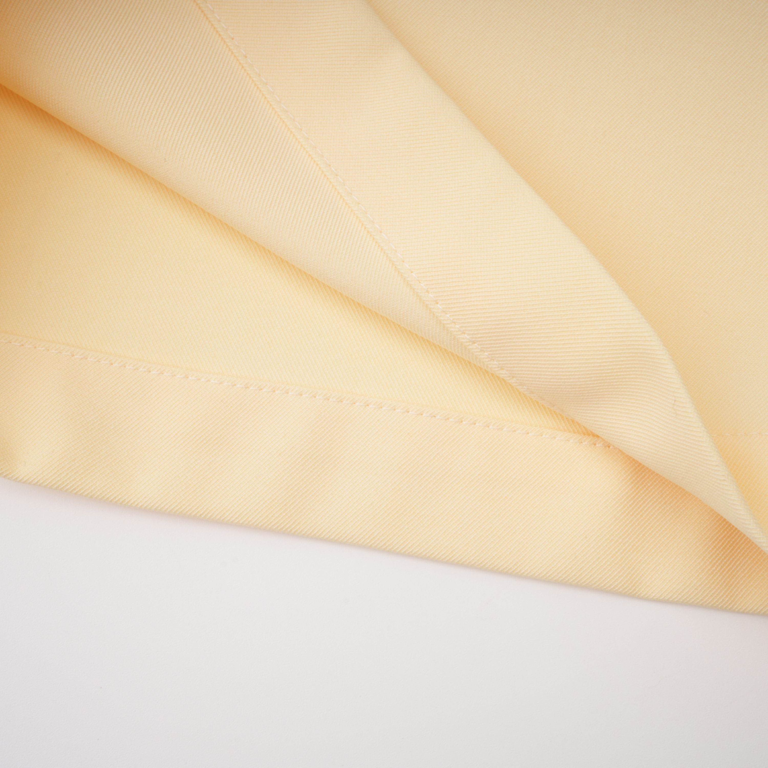 Pale yellow top and trousers set with an asymmetric blazer bodice, draped sheer neckline, and cape panels