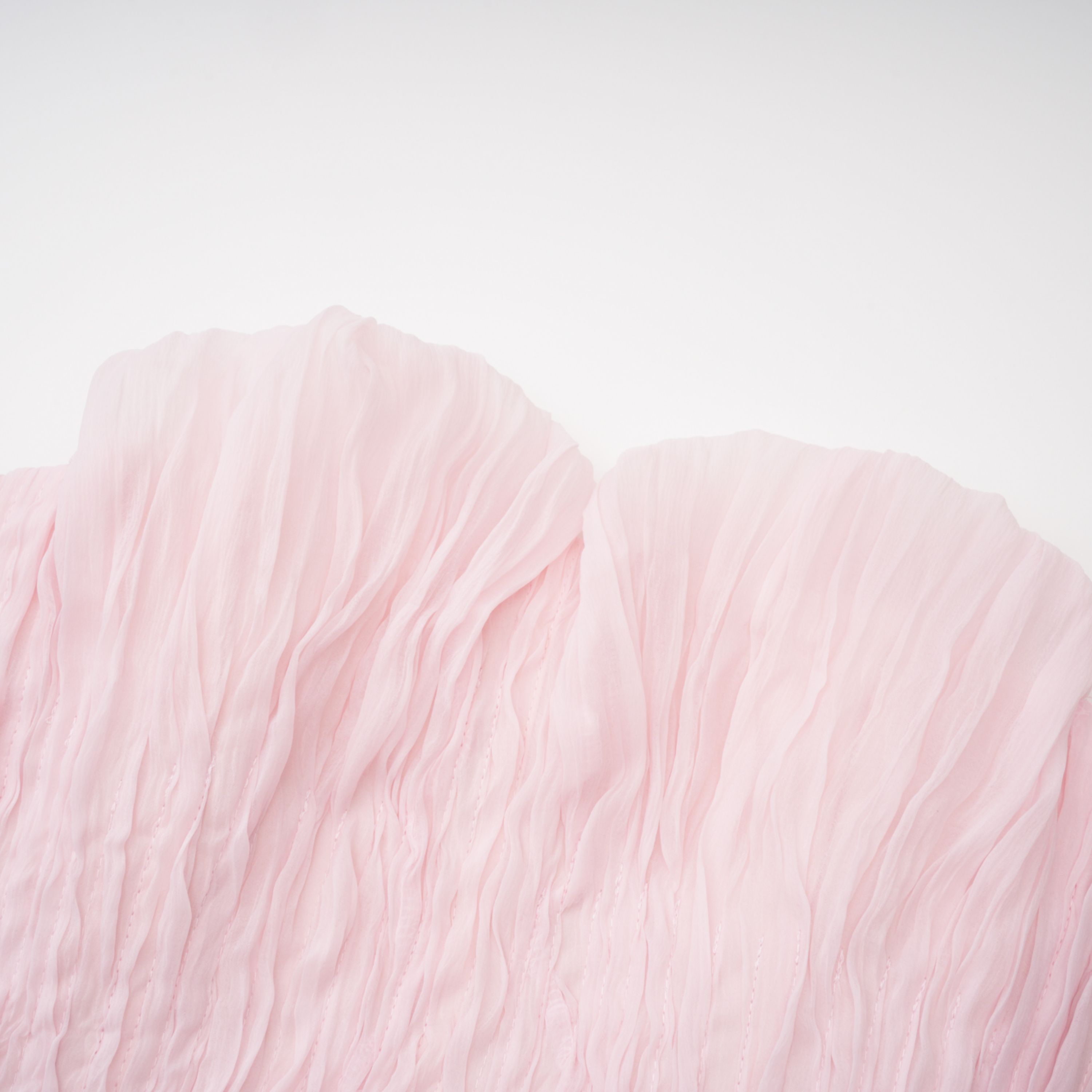 Light pink strapless ruched mini dress featuring a layered ruffle hemline