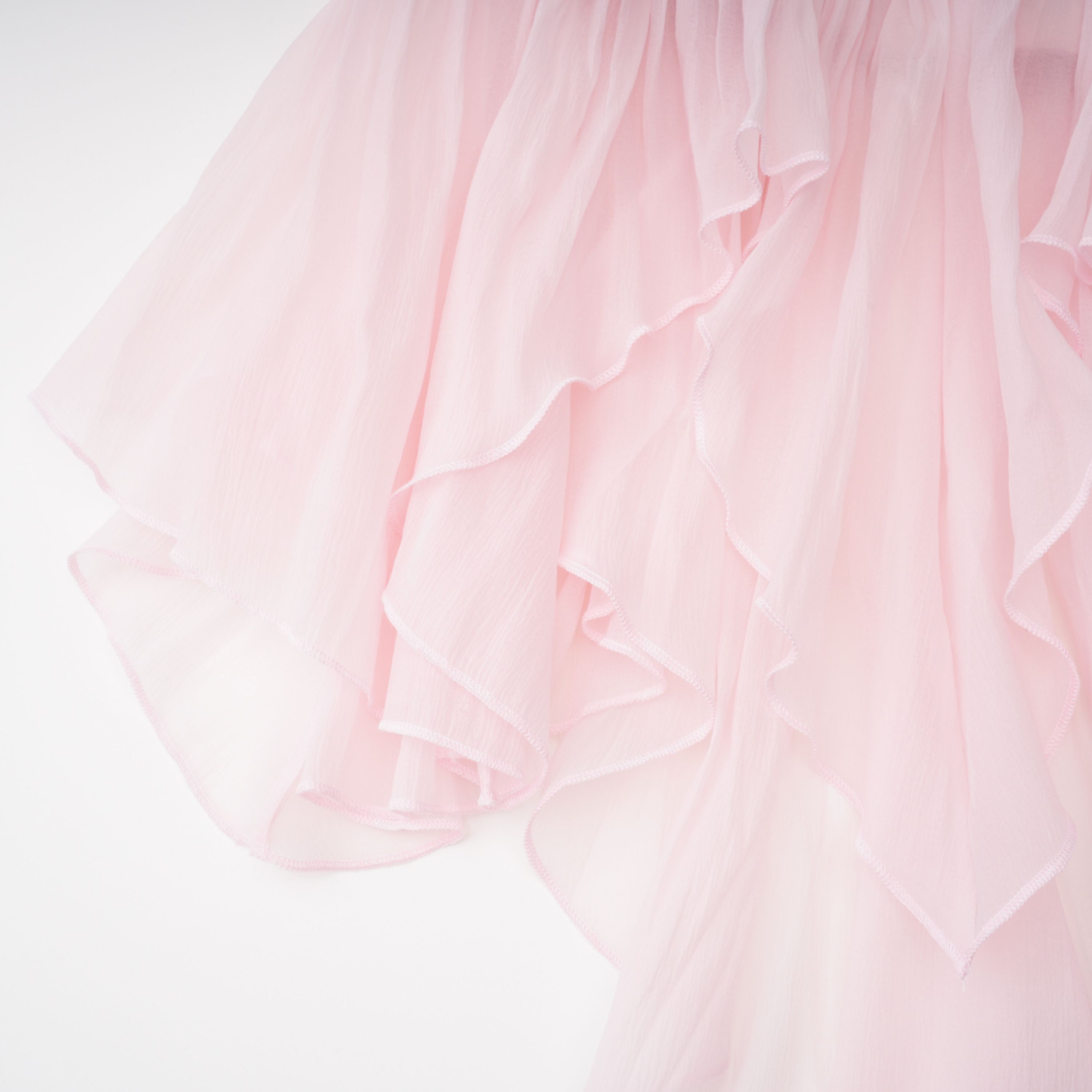 Light pink strapless ruched mini dress featuring a layered ruffle hemline