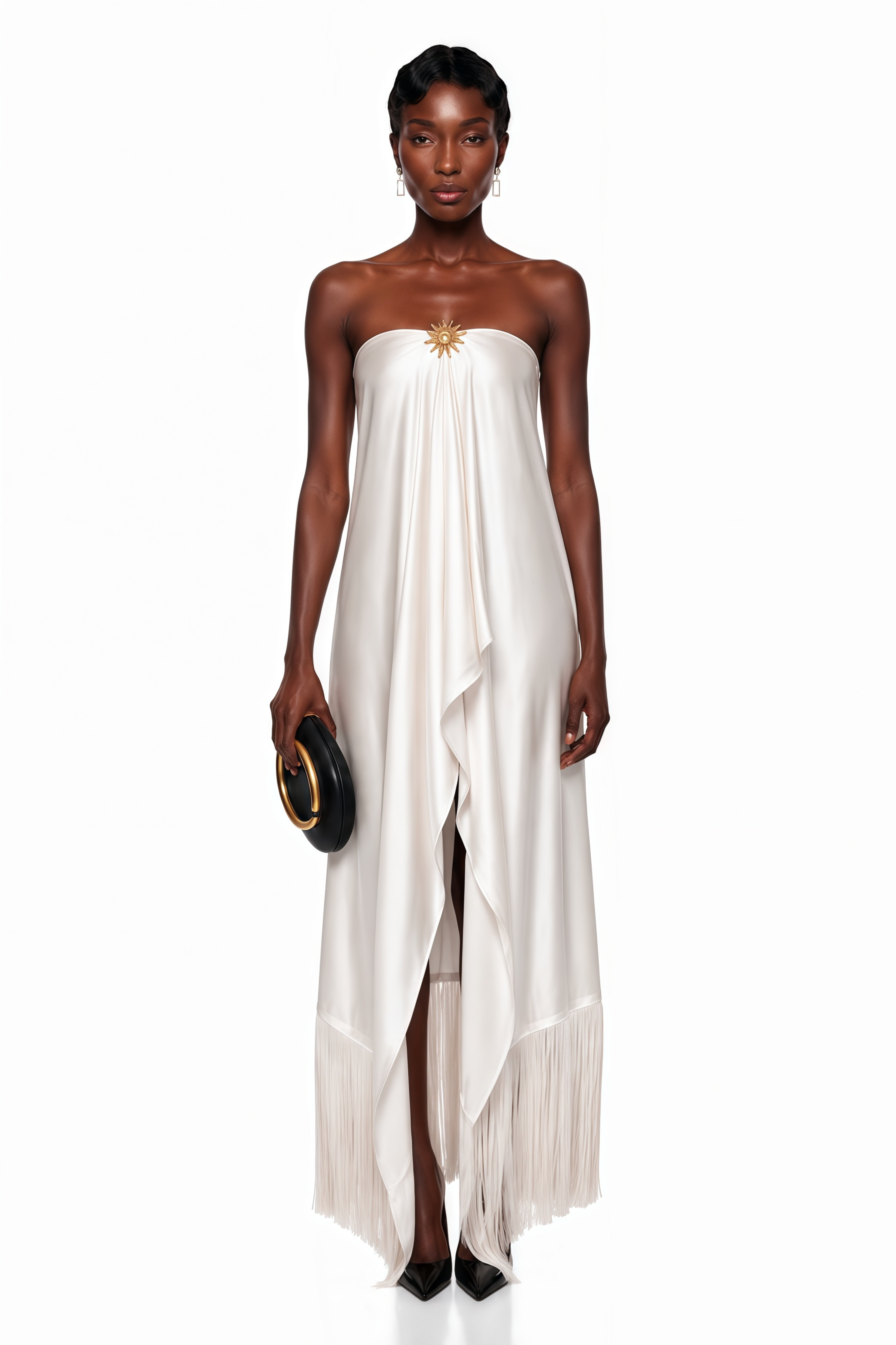 White strapless satin maxi dress with a gold sunburst accent and fringe hem