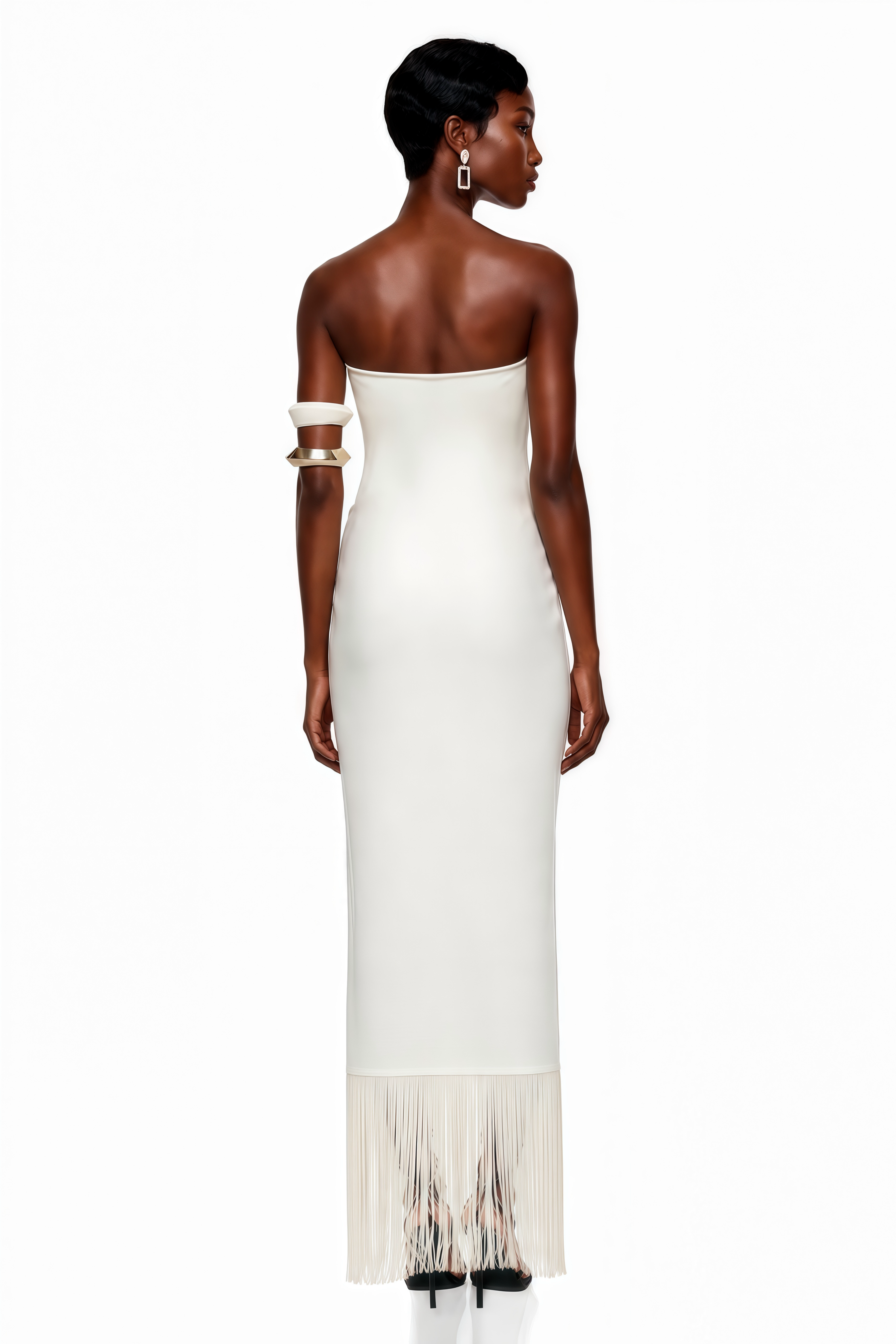 White strapless satin maxi dress with a gold sunburst accent and fringe hem
