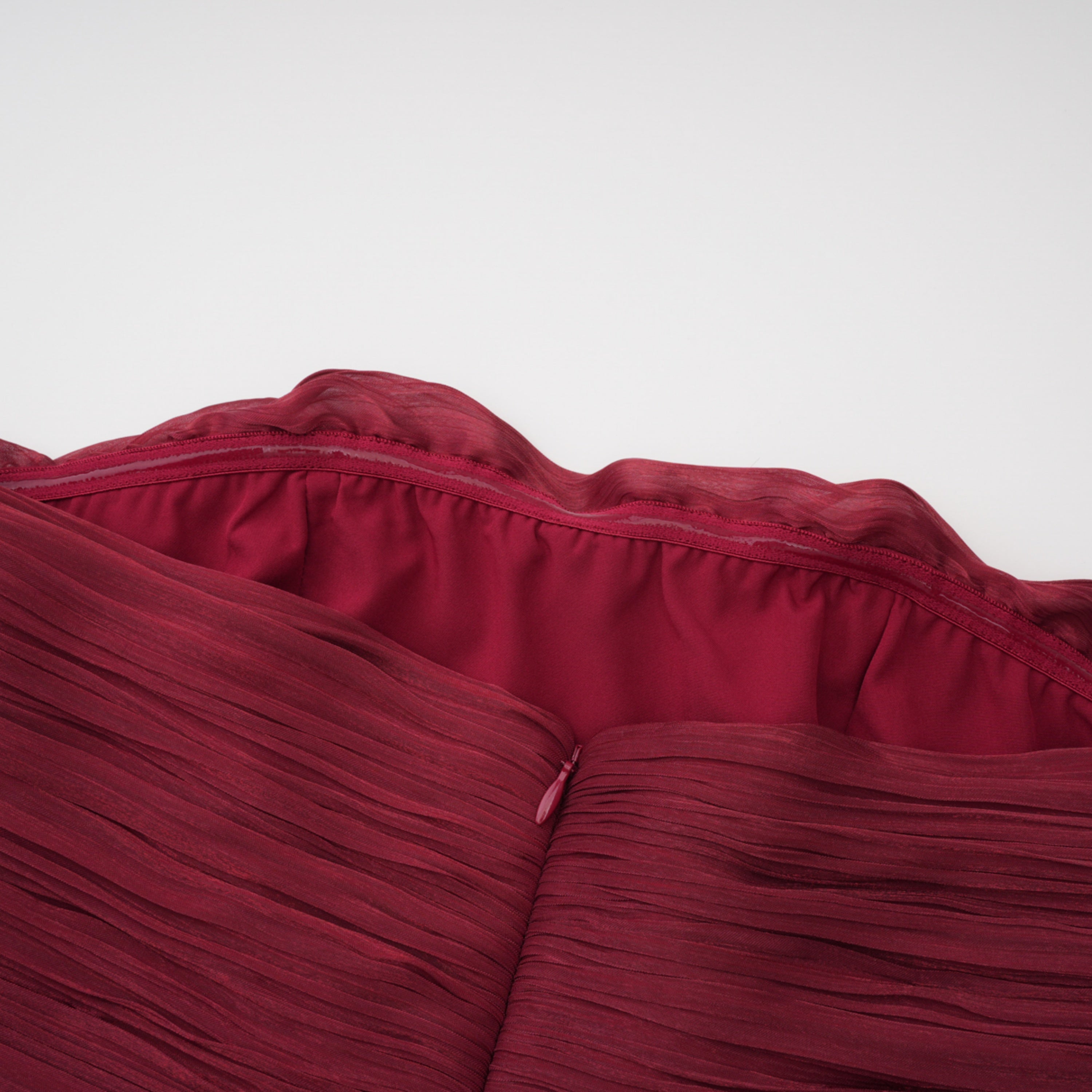 Burgundy pleated strapless gown with matching cape and high slit