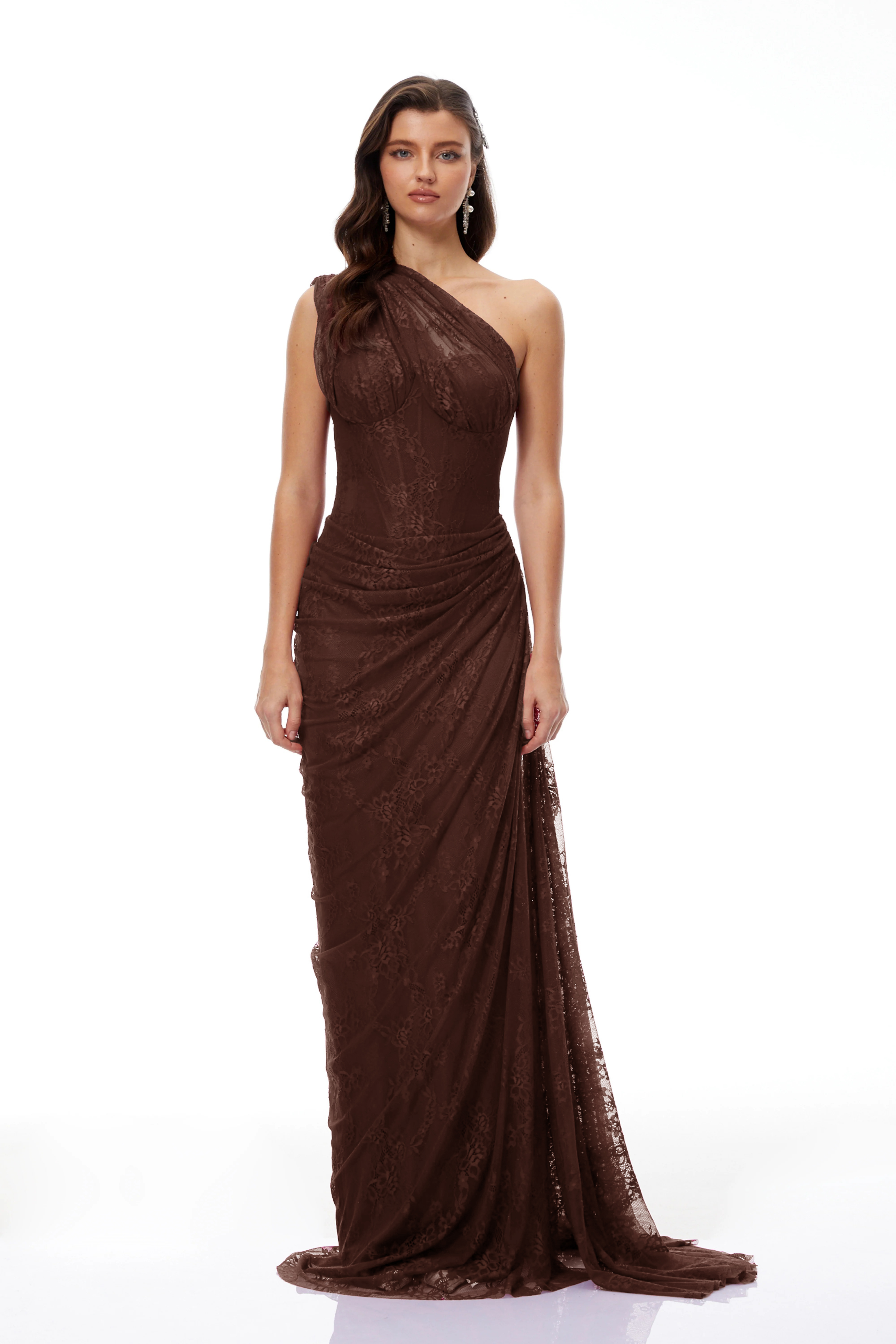 Brown lace maxi dress with a one-shoulder neckline, structured corset bodice, and draped asymmetric skirt