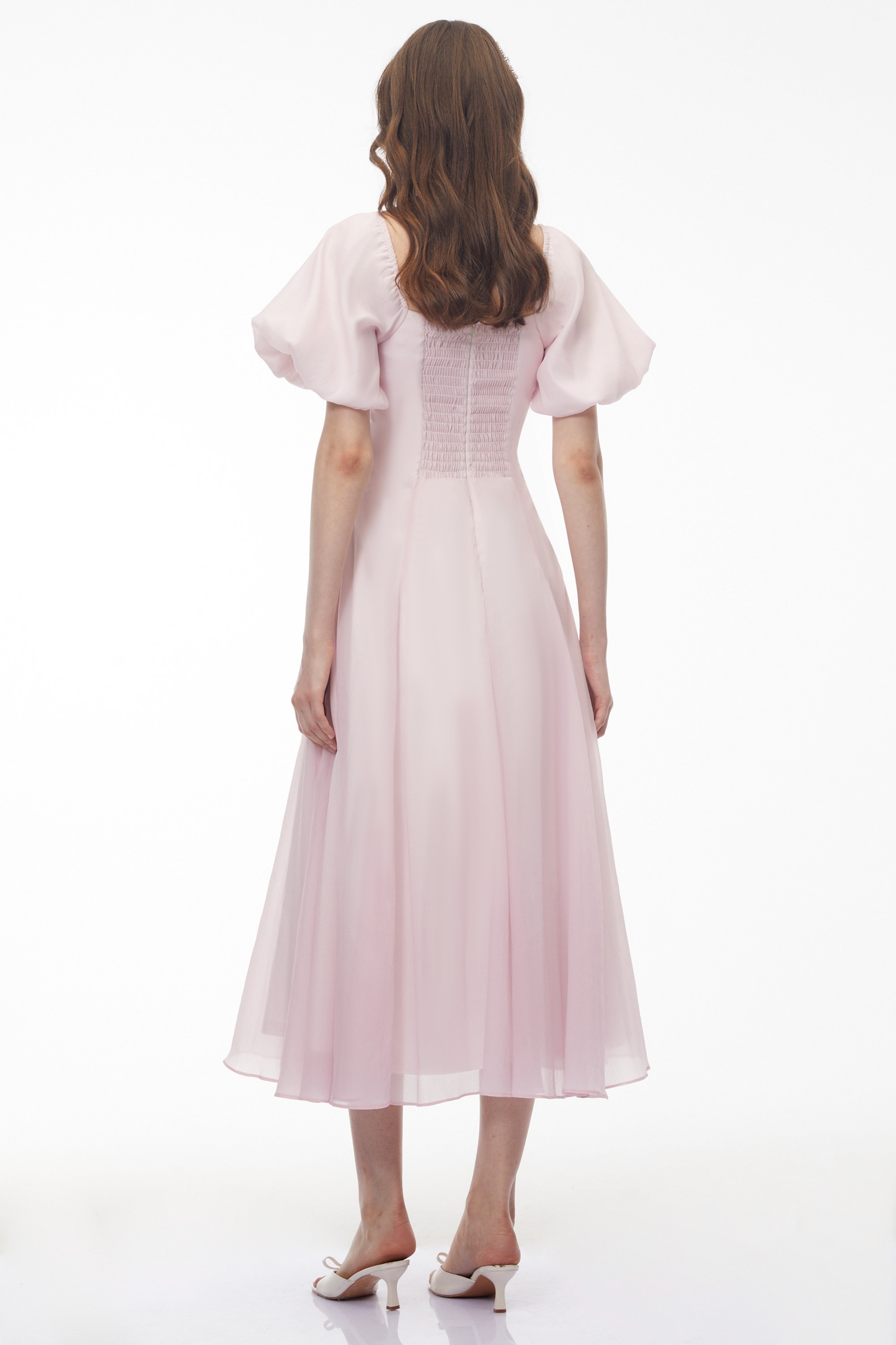 Light pink midi dress with puff sleeves, a ruffled sweetheart neckline, and a pleated skirt