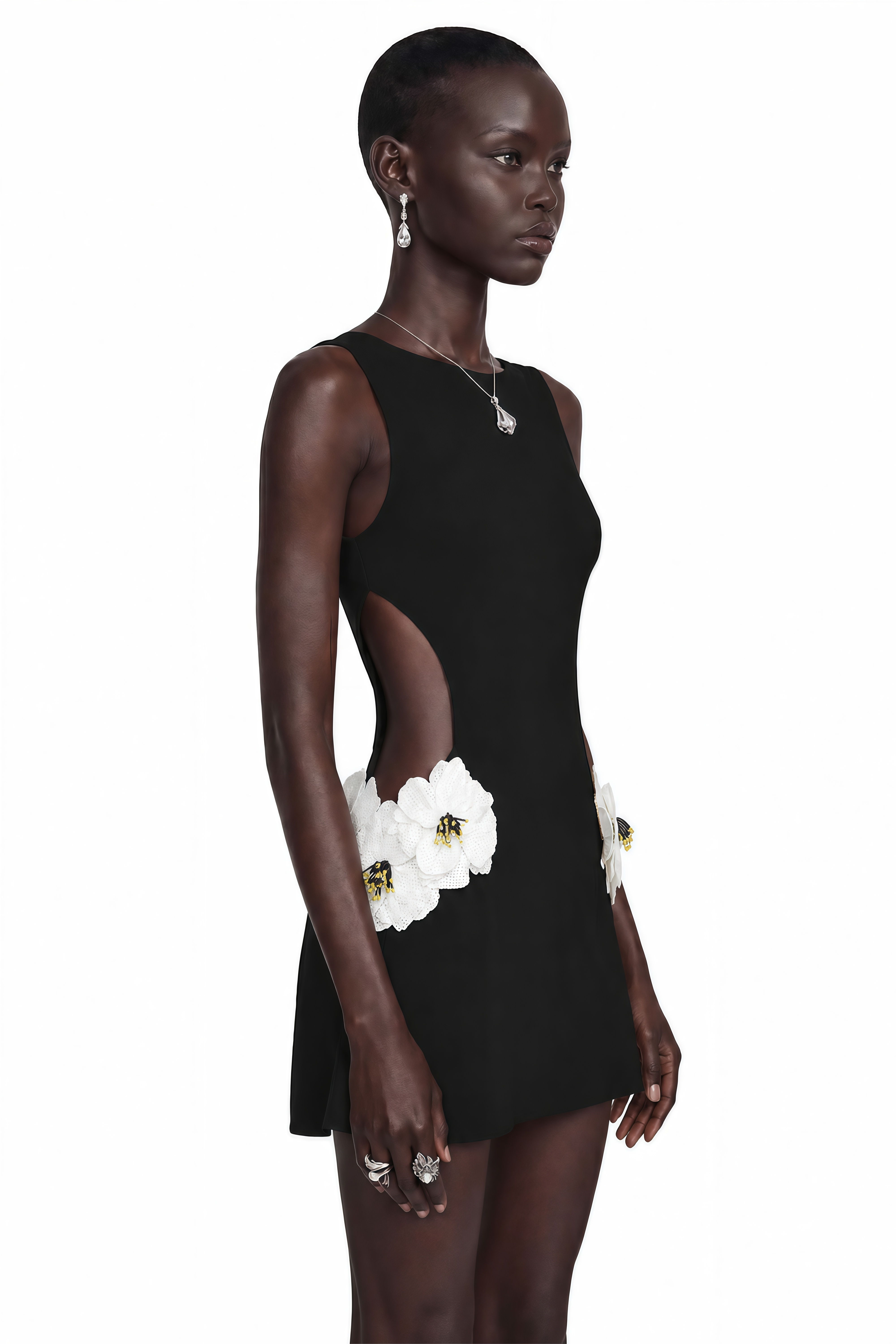 Black sleeveless mini dress with side cutouts and white floral embellishments