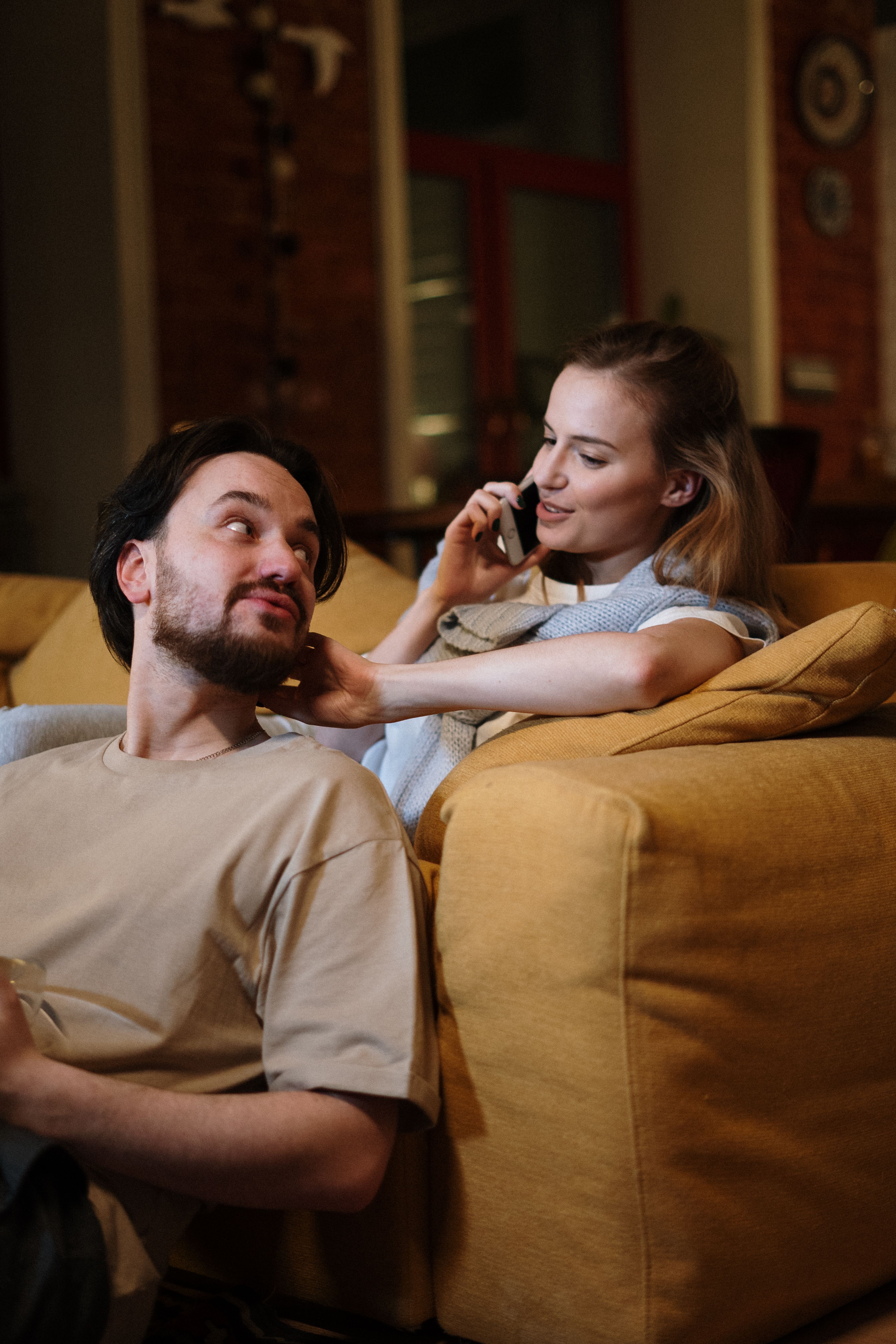 Casal adulto aproveita uma noite tranquila em casa, com luz acolhedora e conversa pr&oacute;xima.