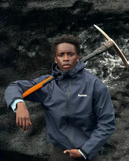 Model wearing the navy reactive jacket near rock