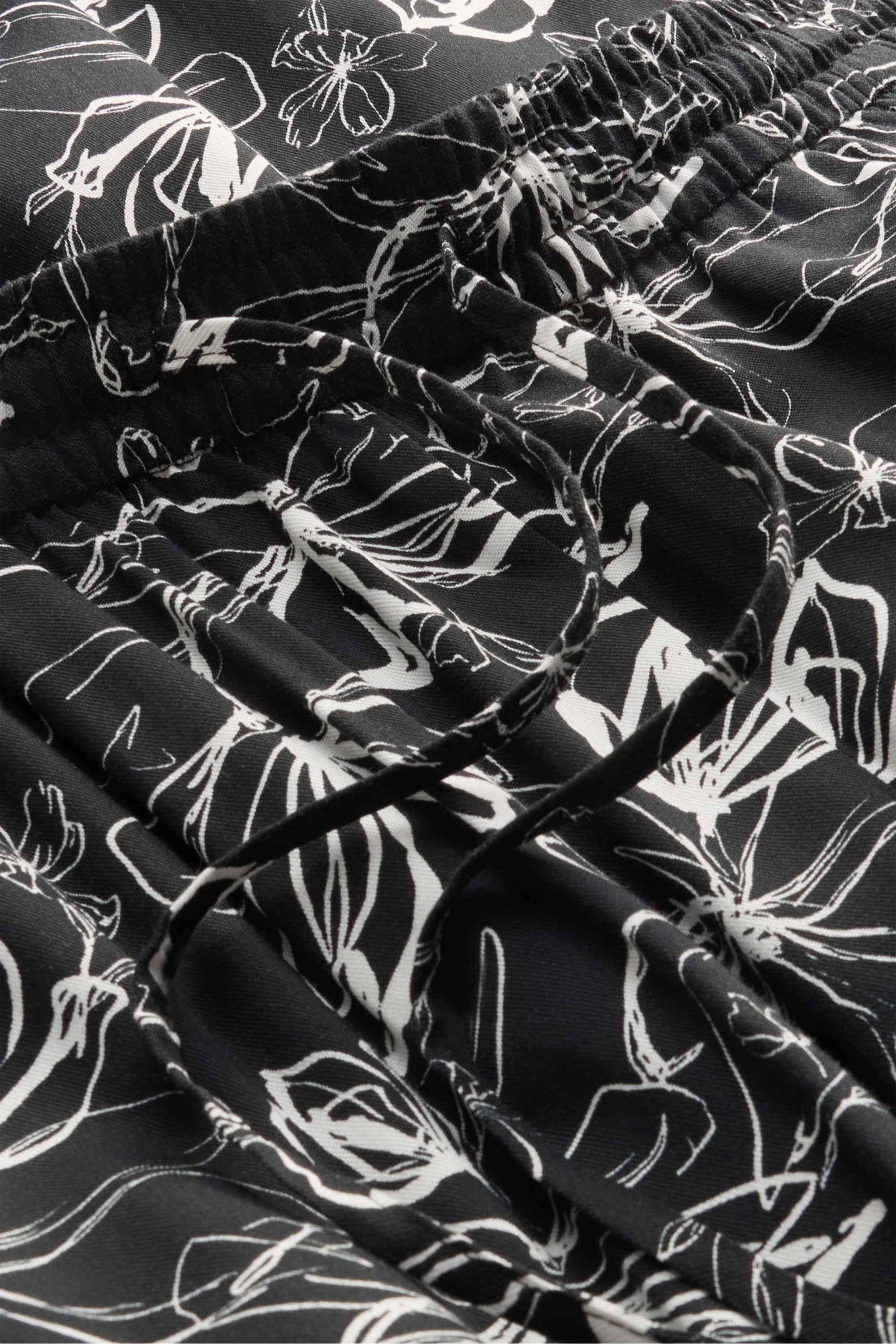 Cloth trousers - mid-rise waist - tapered fit - floral white / black