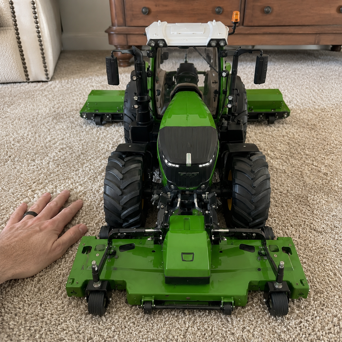 Front view of the green remote-control mower model with a hand for scale