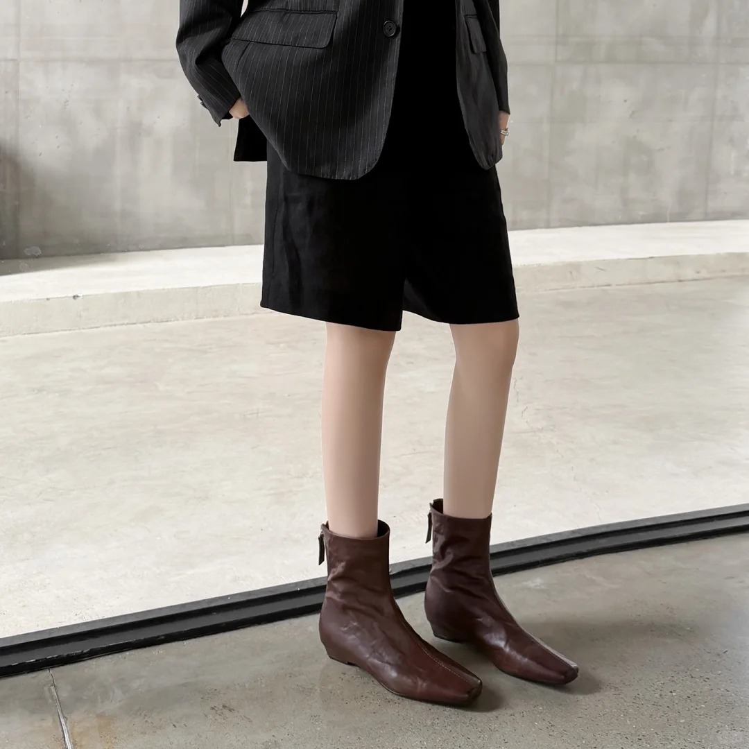 Dark brown leather ankle boots with a back zipper design.