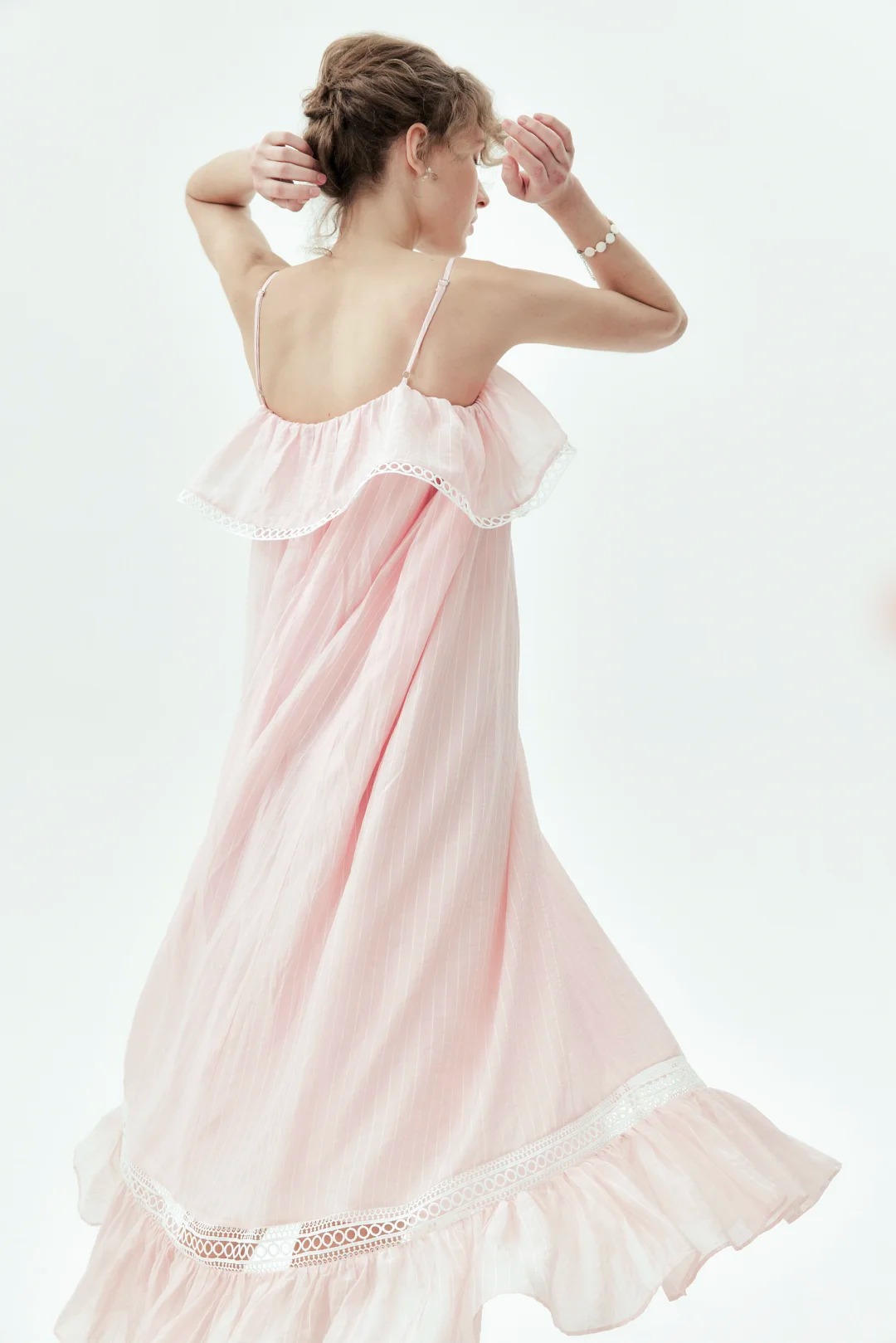 Pink maxi dress with spaghetti straps, featuring ruffle and lace paneling details.