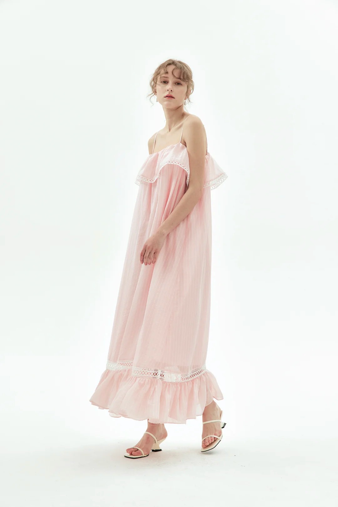 Pink maxi dress with spaghetti straps, featuring ruffle and lace paneling details.