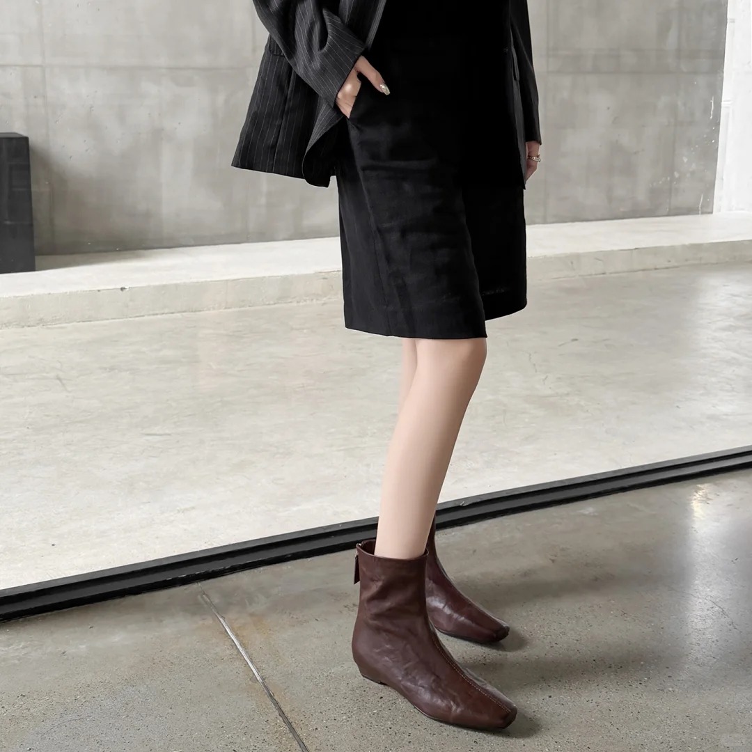 Dark brown leather ankle boots with a back zipper design.