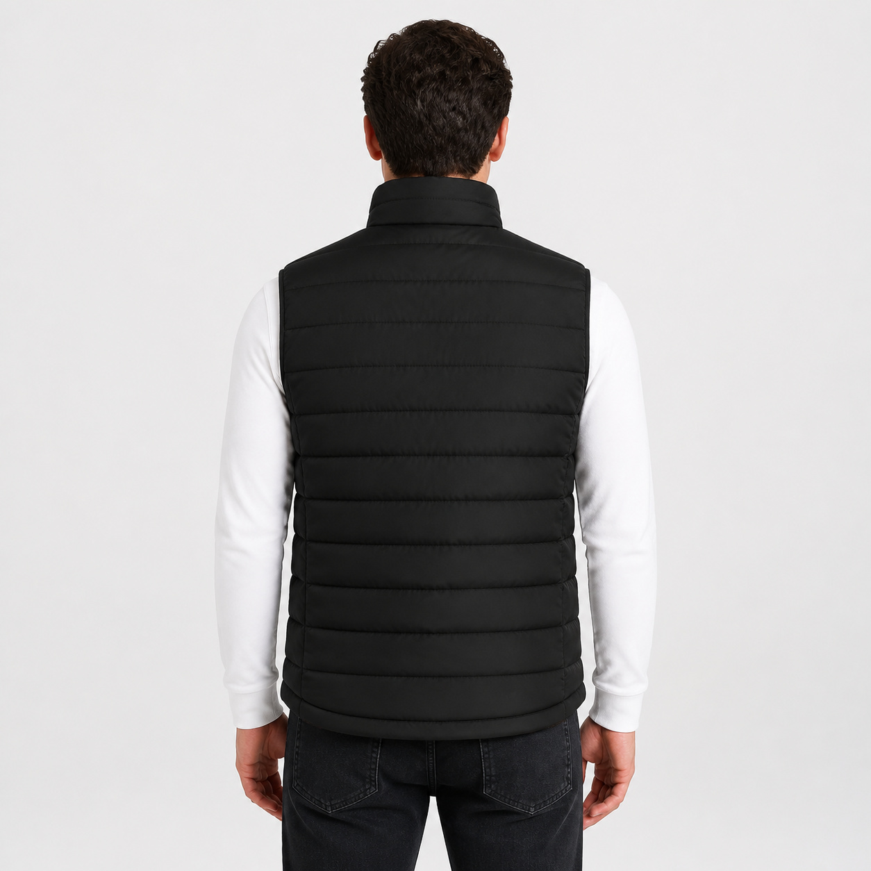 Back view of a male model wearing the black heated vest.
