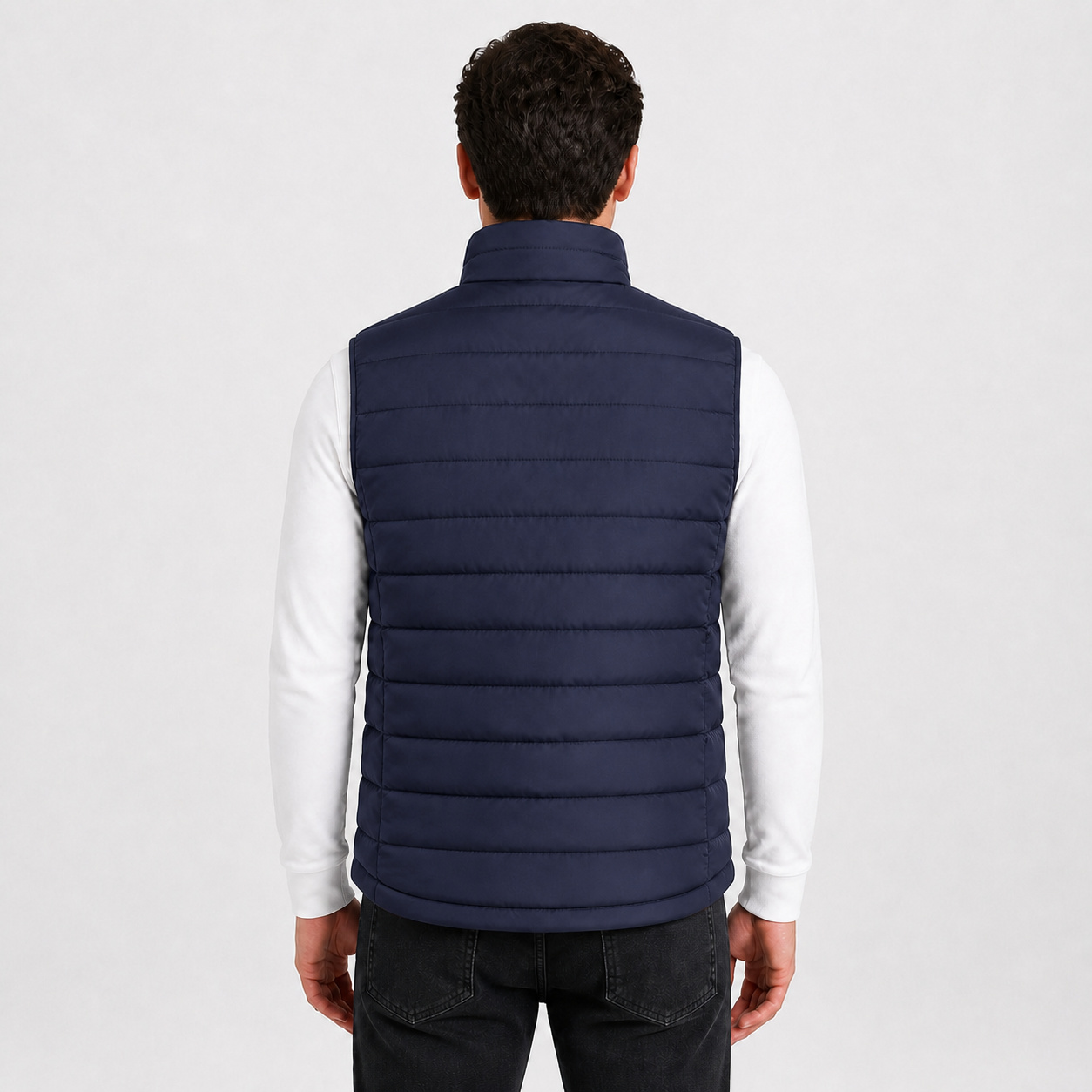 Back view of a male model wearing the blue heated vest.