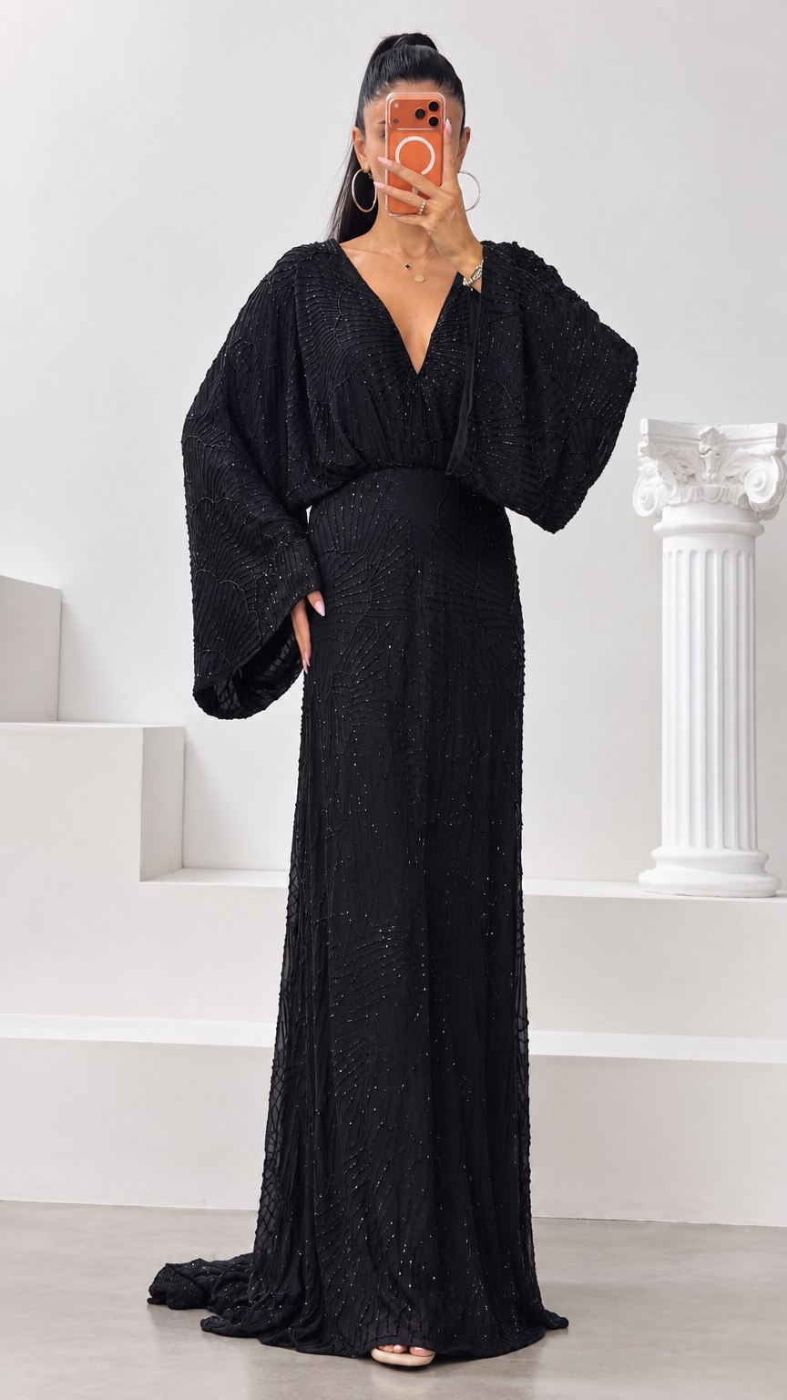 Front view of black deep V-neck beaded evening gown with dramatic batwing sleeves