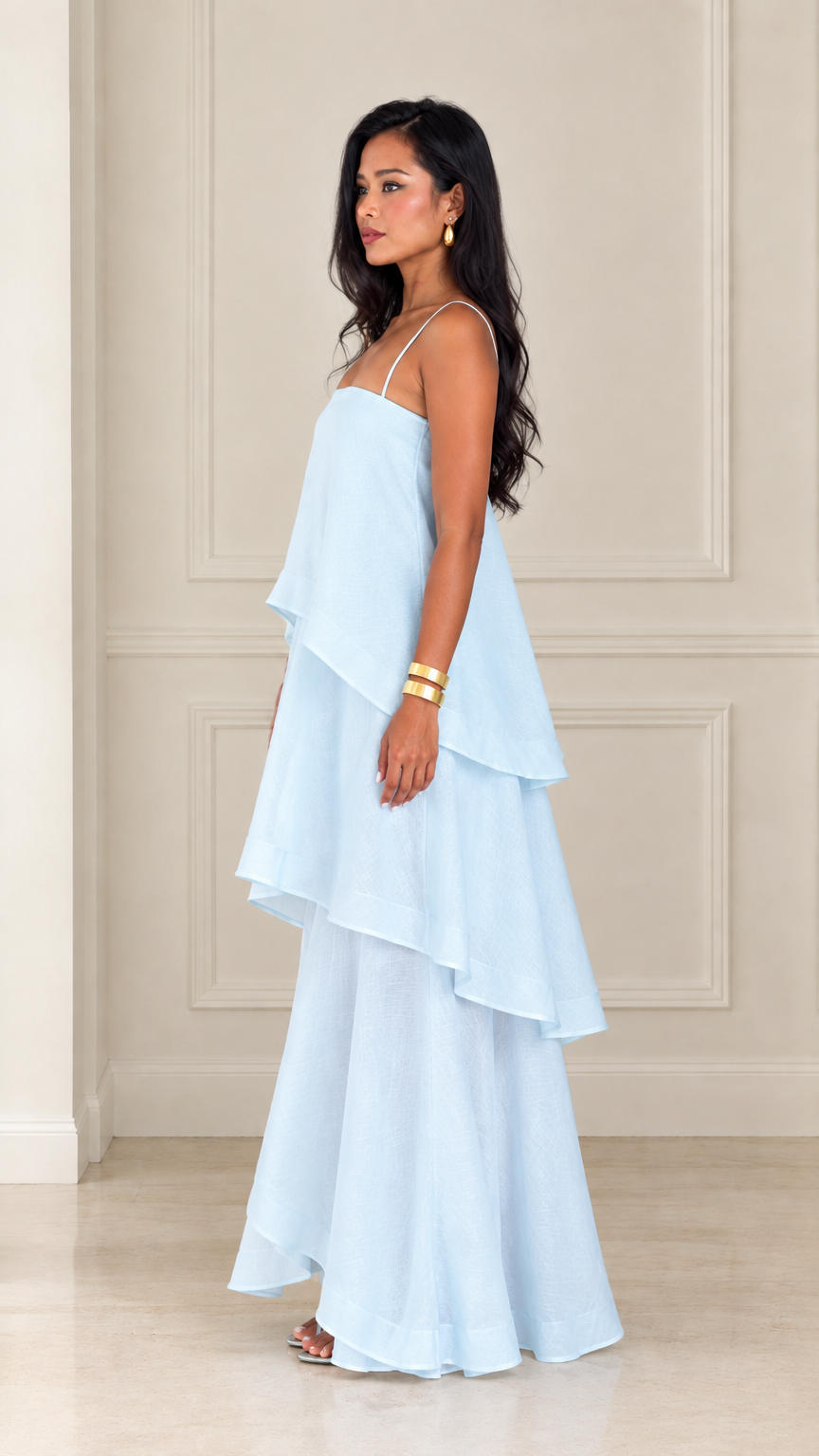 Side profile view of woman wearing light blue tiered spaghetti strap maxi dress