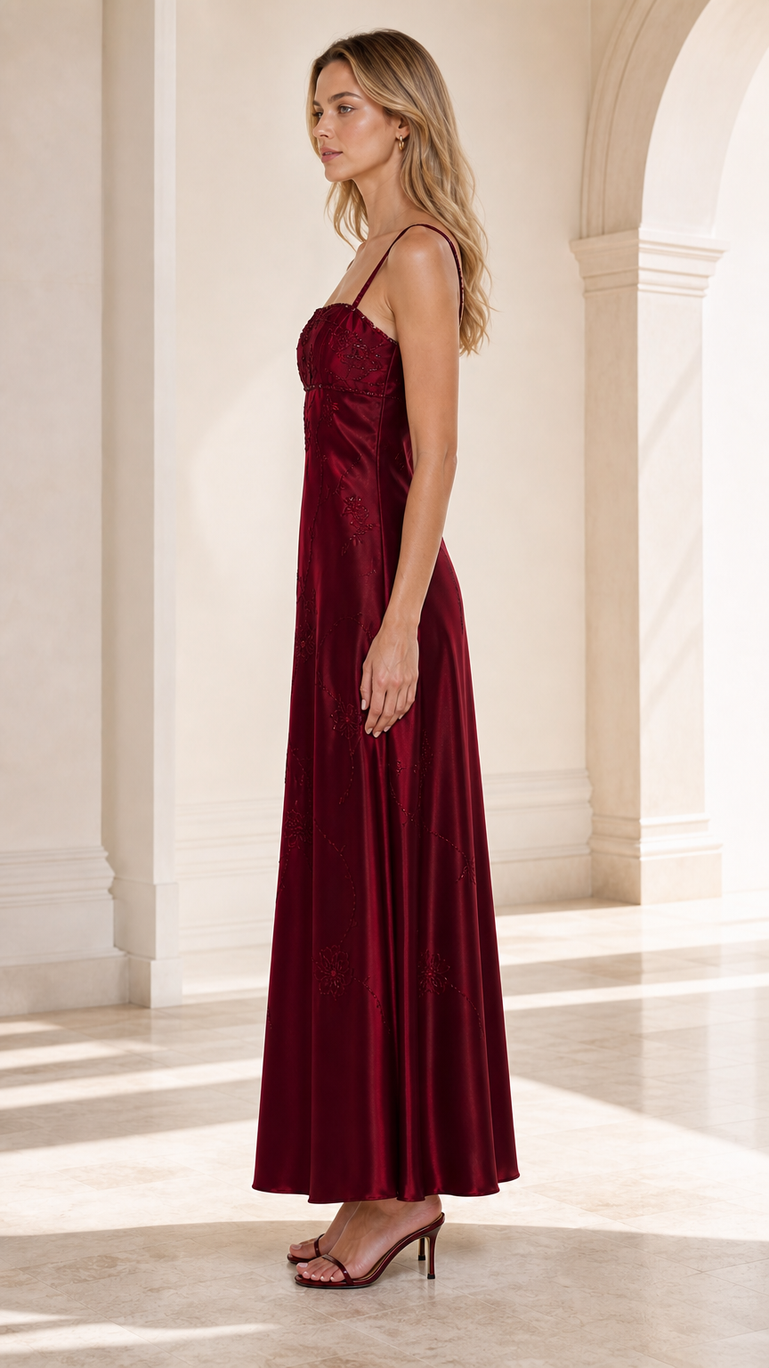 Side profile view of woman wearing Burgundy embroidered satin maxi dress
