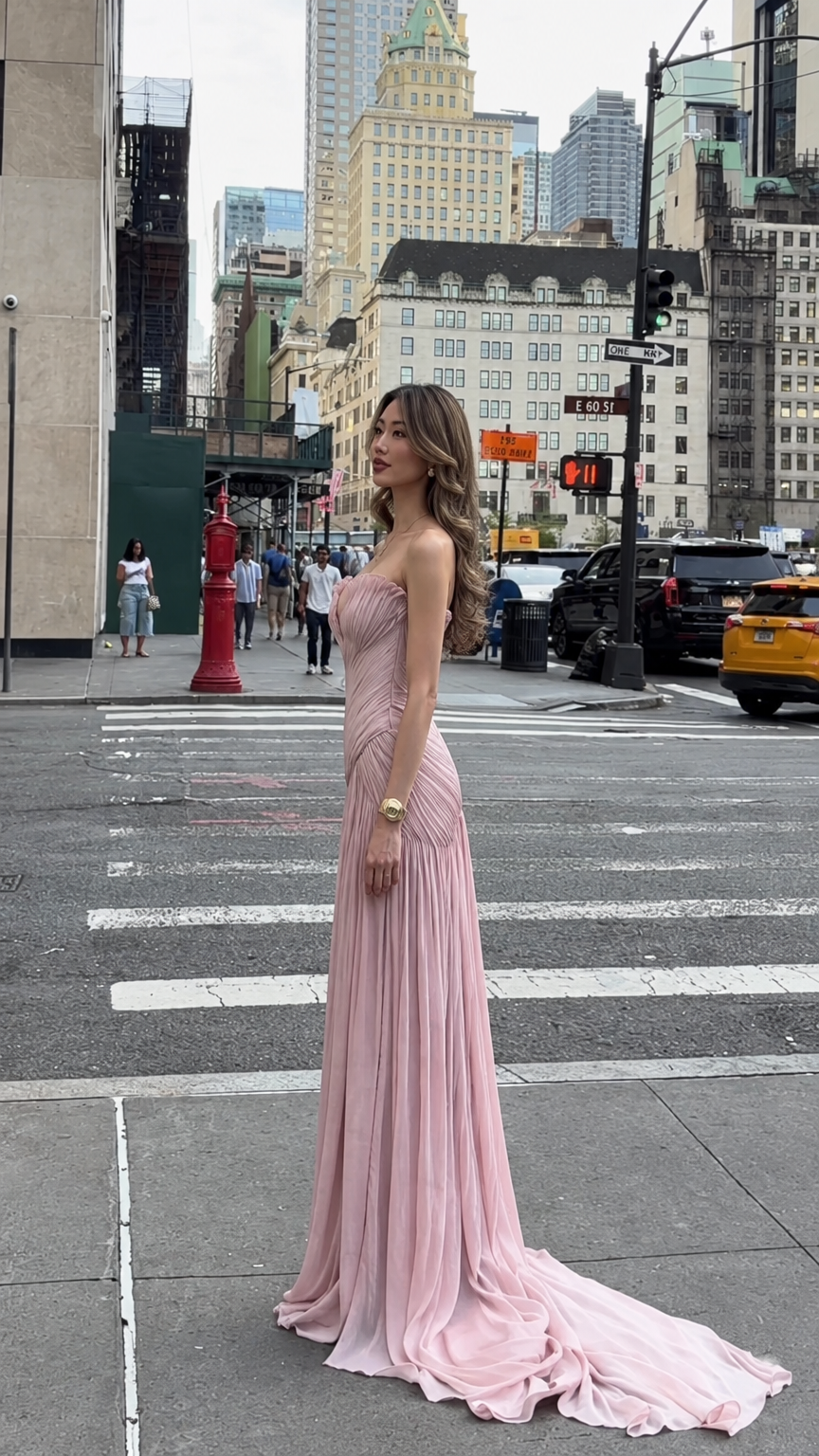 Side profile of woman wearing blush pink strapless pleated formal gown