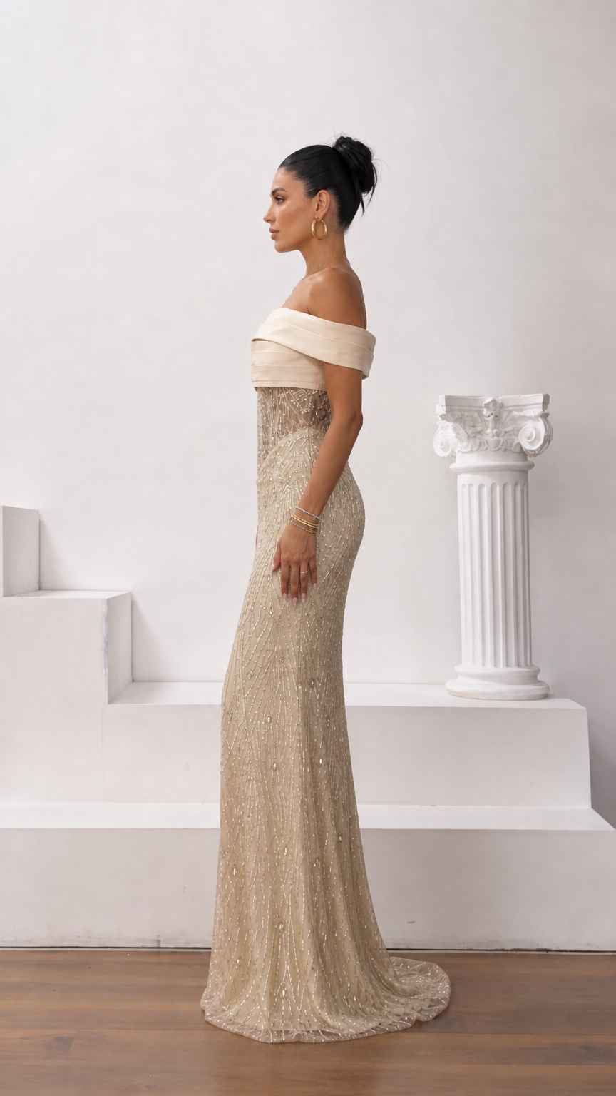 Side profile view of champagne gold off-the-shoulder sequin formal dress with sweep train