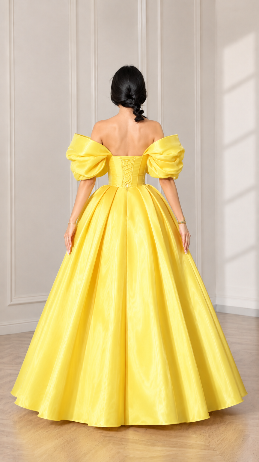 Back view of model showcasing the yellow gown with off-shoulder puff sleeves