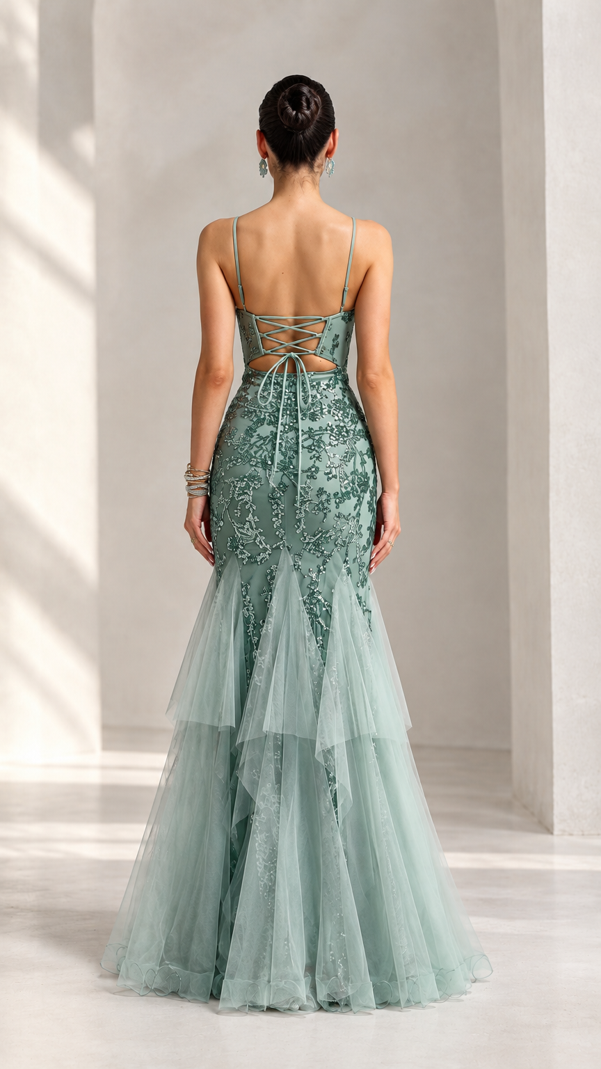 Back view of sage green formal evening gown featuring lace-up corset back detail and tiered tulle skirt