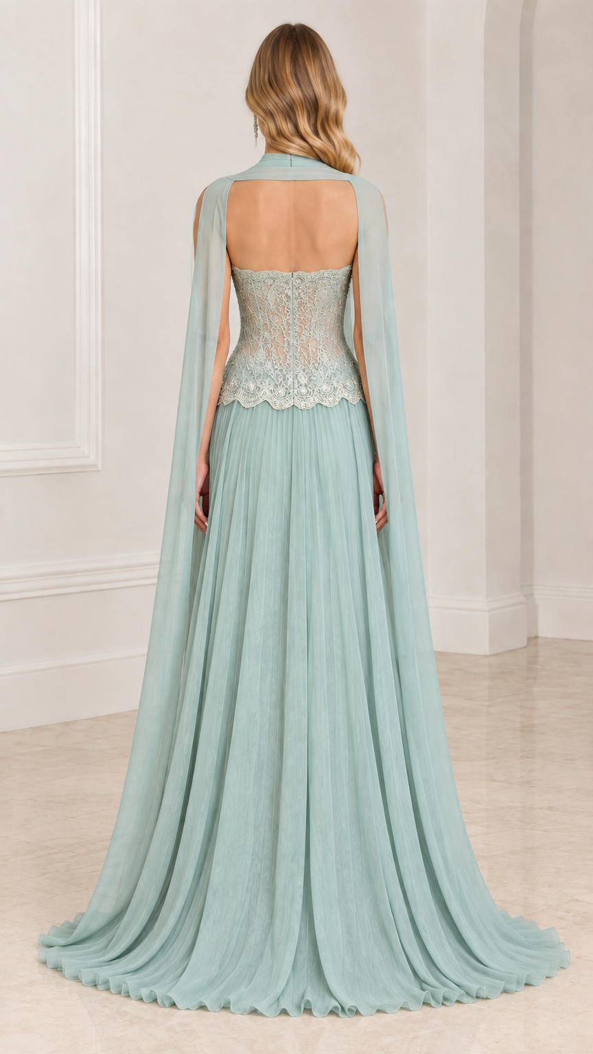 Back view of model showcasing open back and sheer flowing cape on sage green evening dress