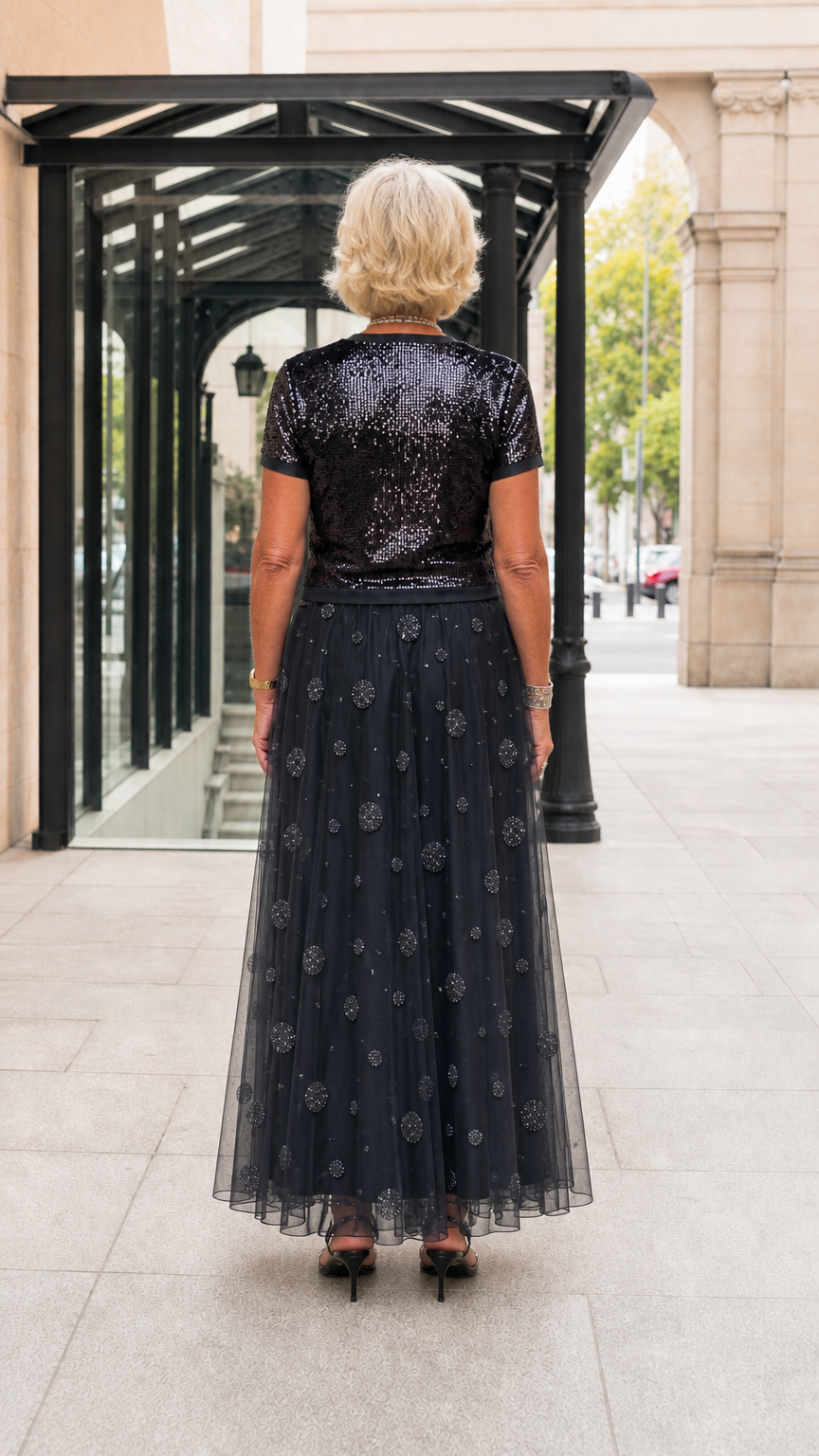 Back view of black sequin short-sleeve top and flowing tulle maxi skirt