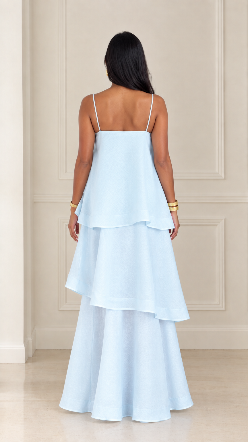 Back view of woman wearing light blue tiered spaghetti strap maxi dress