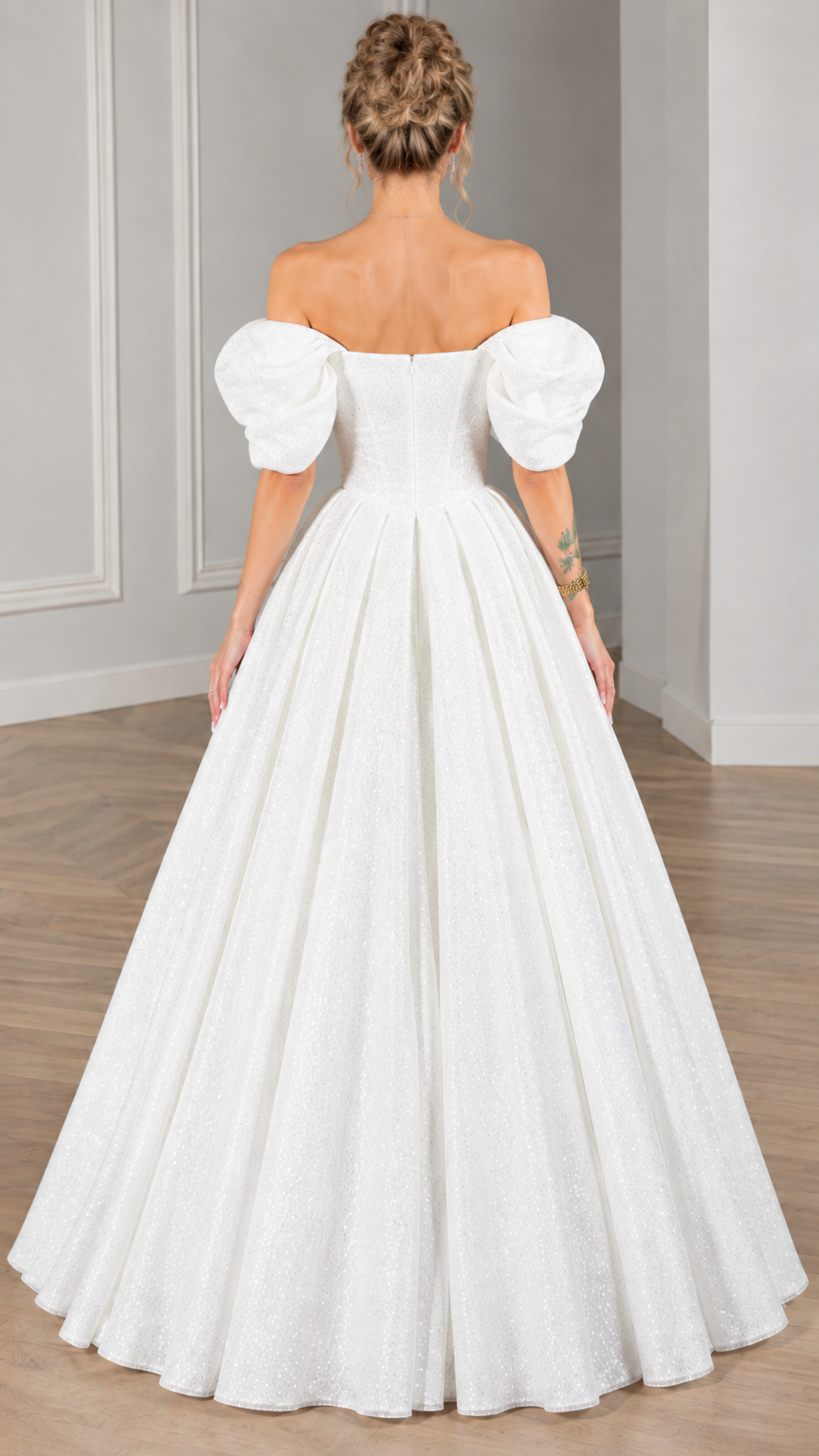 Back view of model wearing white puff-sleeve formal ball gown