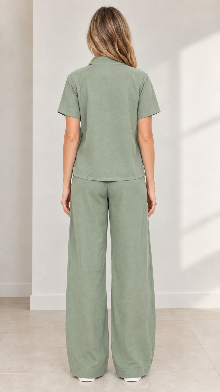 Back view of model wearing Sage Green button-up shirt and wide-leg matching trousers