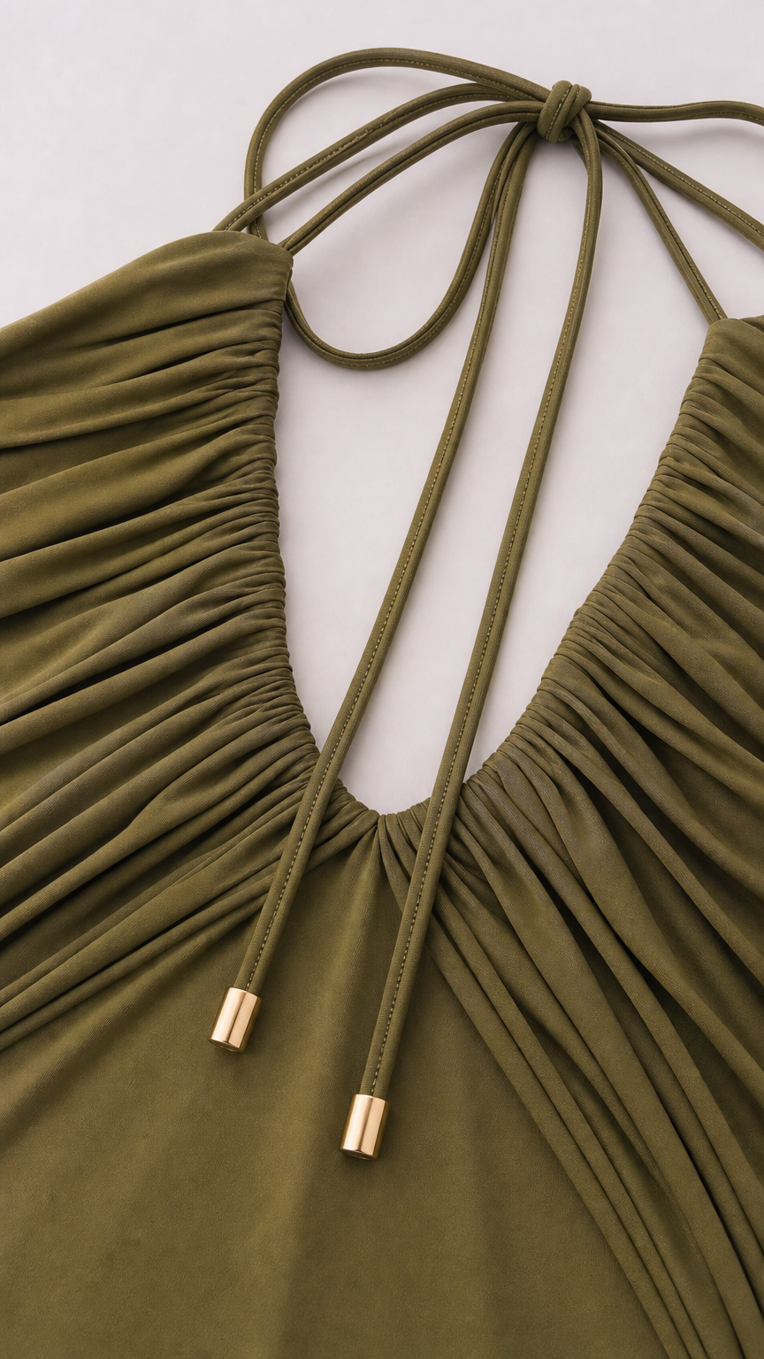 Close-up detail of pleated bust and halter ties with gold-tone hardware