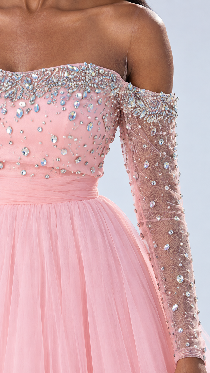 Close-up detail of rhinestone and crystal embellishments on pink bodice and sheer long sleeve