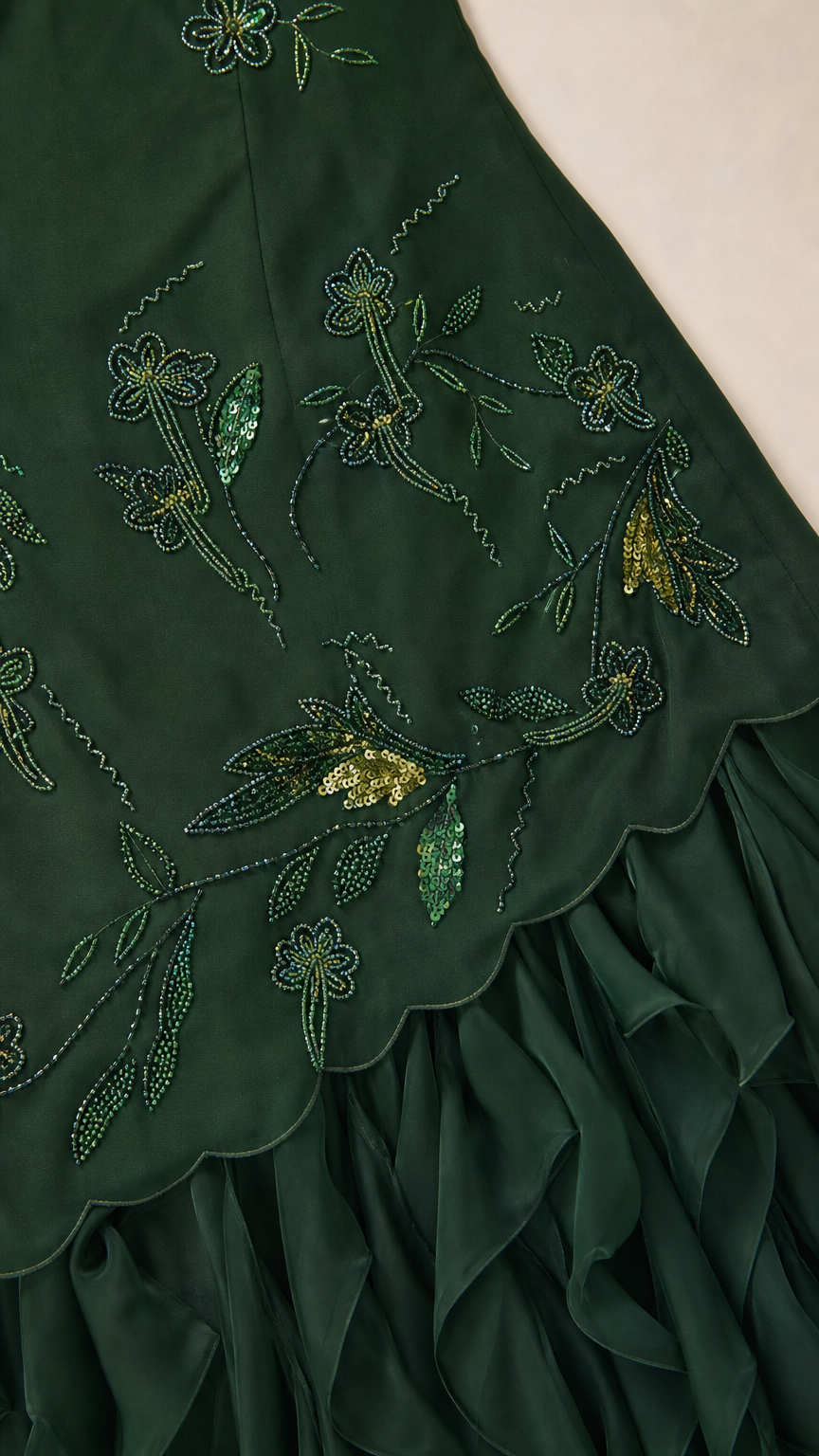 Close-up detail of embroidered floral beadwork and scalloped ruffle hem